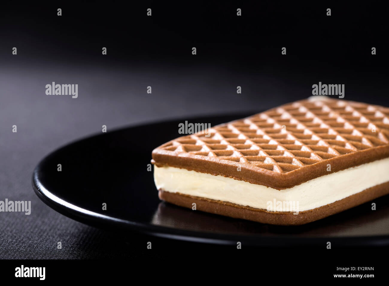 Ice Cream Sandwich auf einer dunklen Platte mit schwarzem Hintergrund Stockfoto