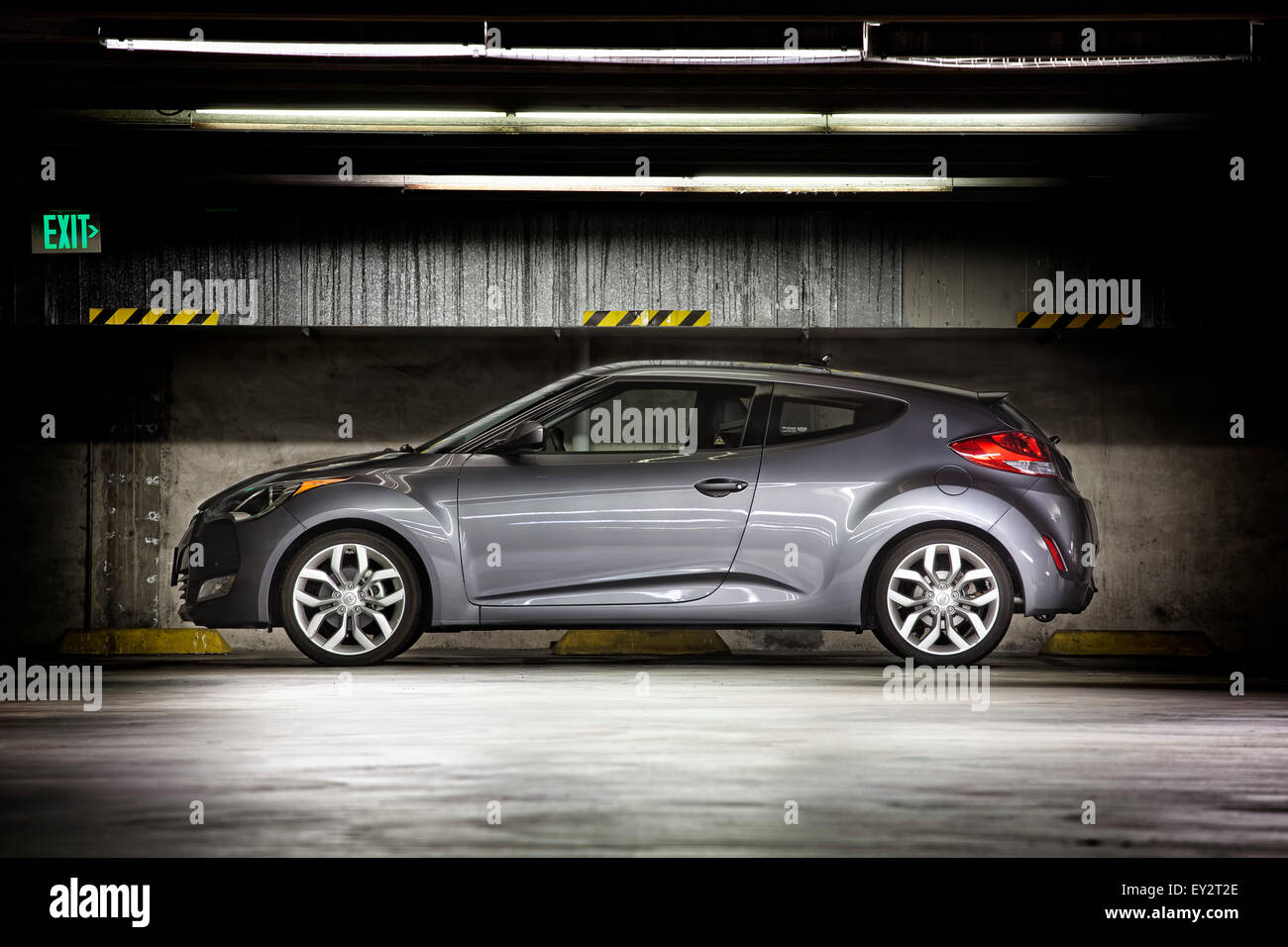 Hyundai Veloster geparkt in der Nacht, in einer Multi-Geschichte-Garage unter Lichtleisten. Stockfoto