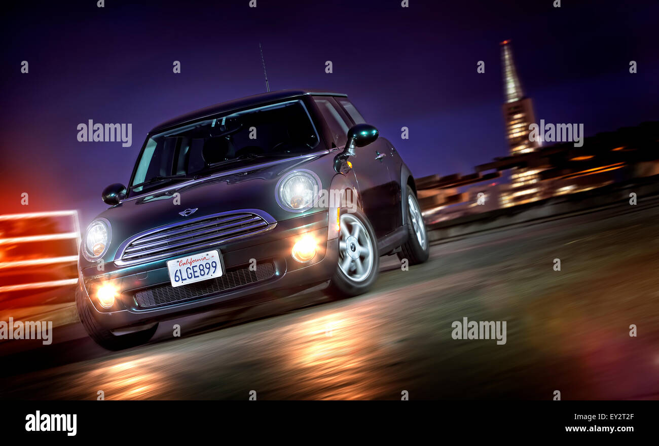 Mini fahren bei Nacht in San Francisco mit der Trans-Amerika-Pyramide im Hintergrund. Stockfoto
