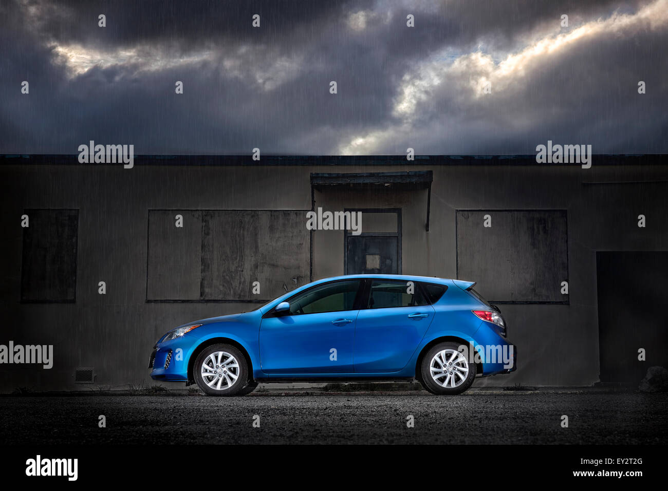 Blauen Mazda 3 Hatchback geparkt im Regen Stockfoto