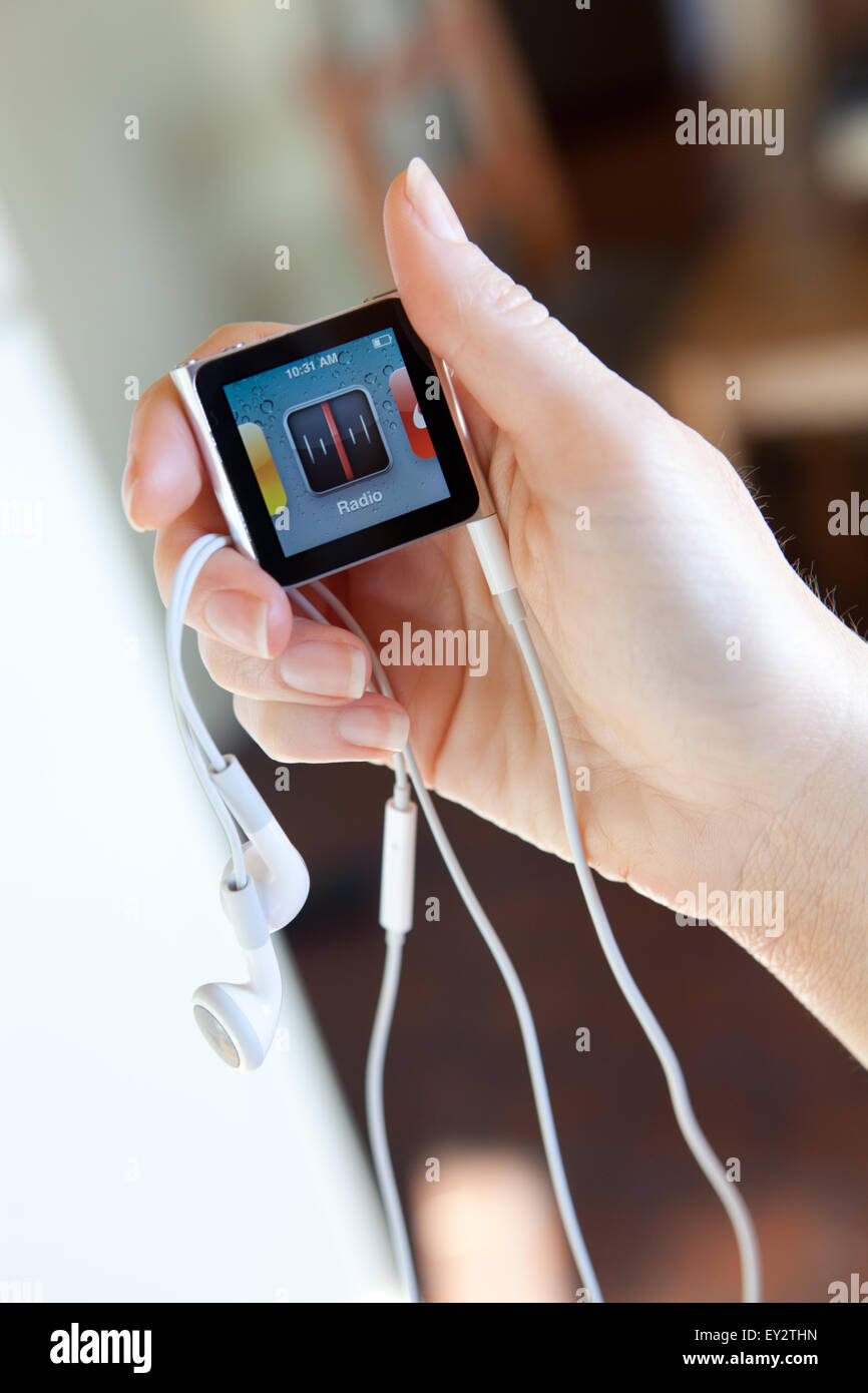 Nahaufnahme von einem Apple iPod Nano mit Kopfhörern, hielt in einem Womans Hand zeigt der Bildschirm "Radio". Stockfoto
