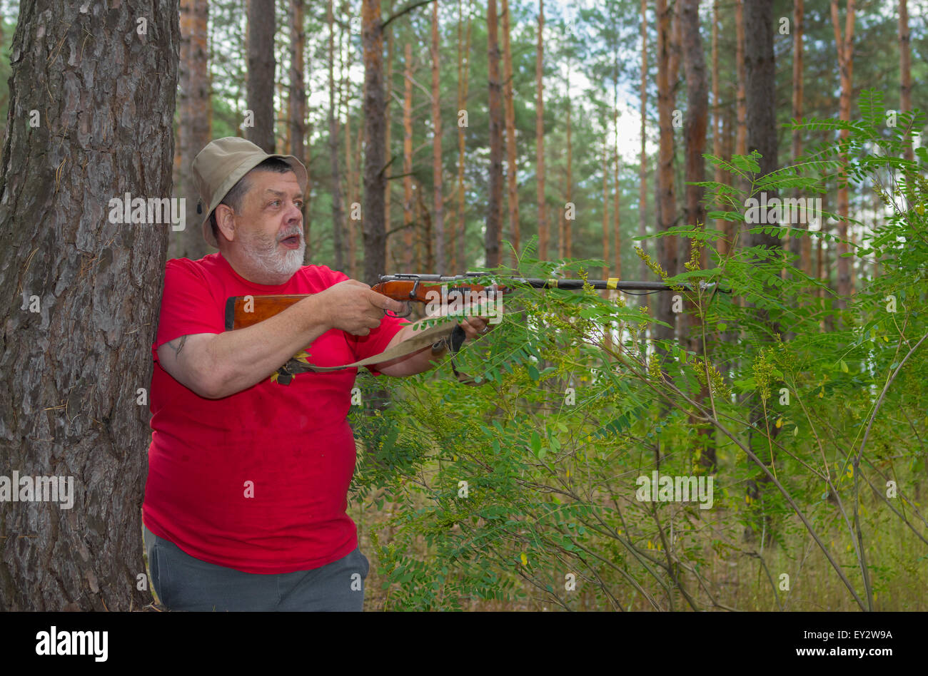 Alte Jäger auf der Suche nach einem großen Tier während der Dreharbeiten im Wald Stockfoto