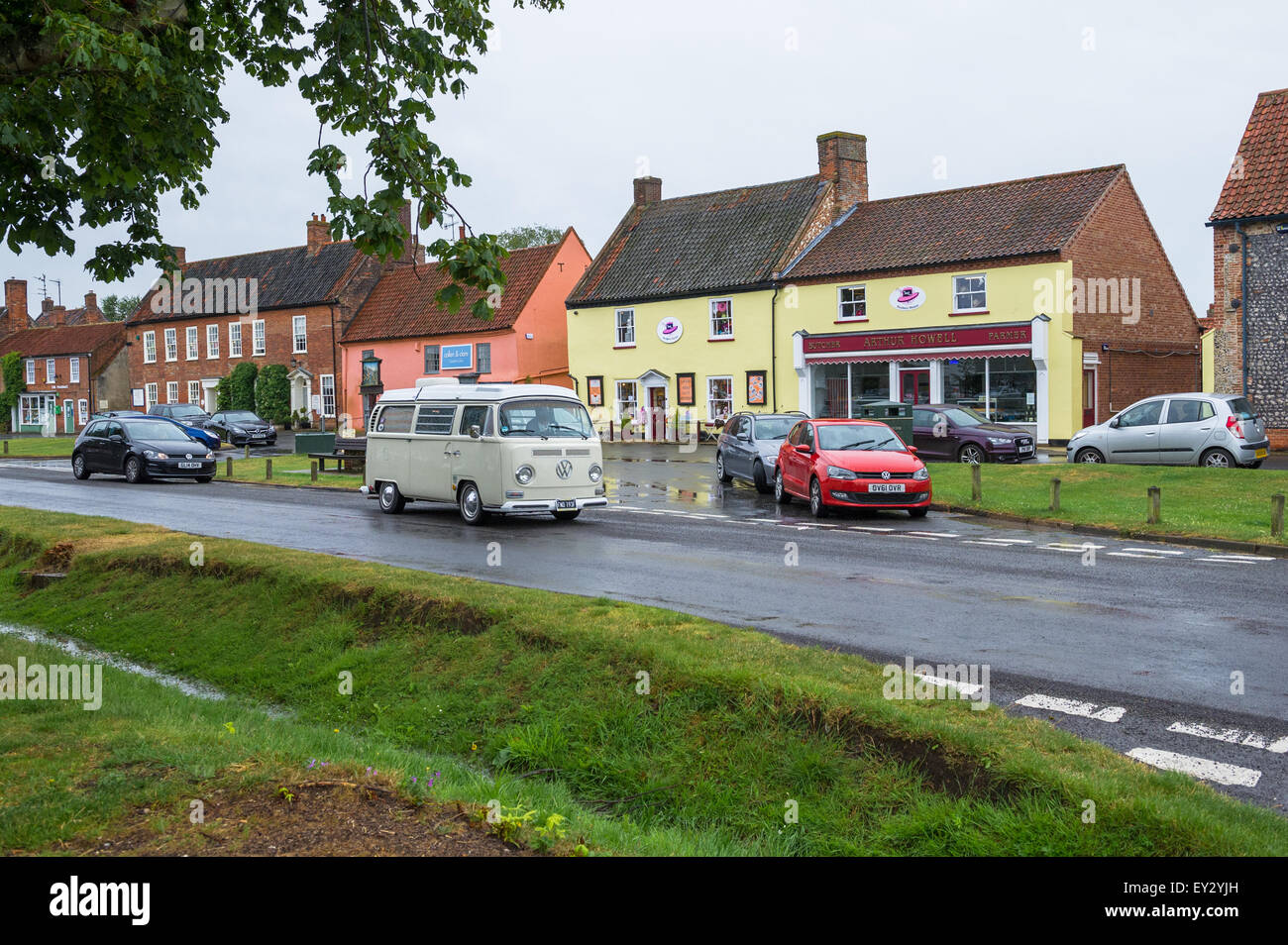 Sahnen Sie Volkswagen T2 Wohnmobil fahren durch das Dorf von Burnham Ländermarkt in Norfolk, England. Stockfoto