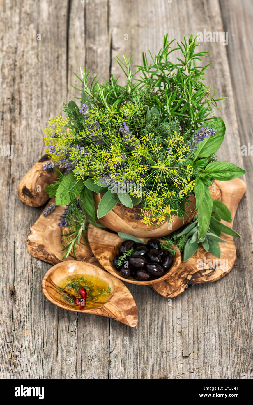 Oliven, Öl, Basilikum, Dill, Salbei, Lavendel, Minze. Gesunde Ernährung. Kräuter und Gewürze über rustikale Holz Hintergrund Stockfoto