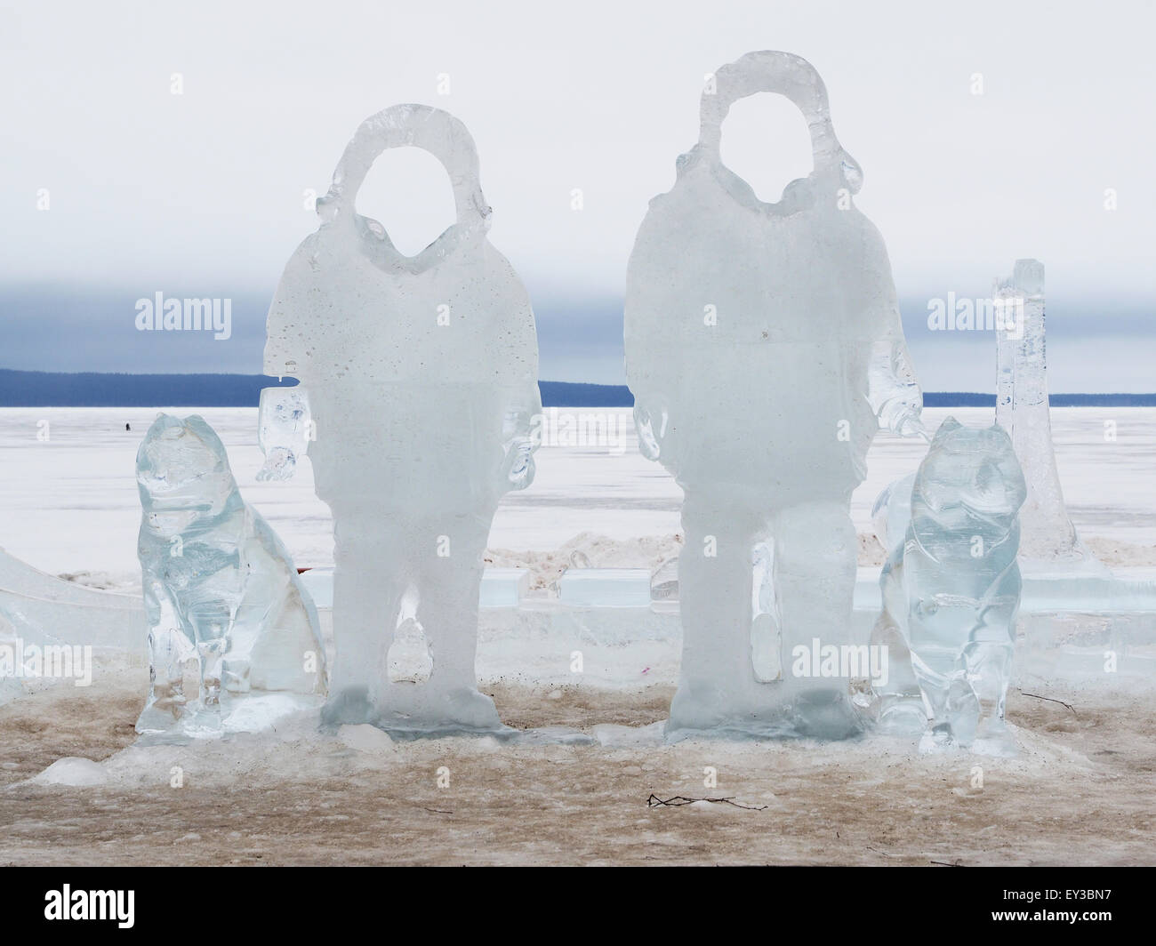 Eis-Statuen von Männern mit Hunden am See Stockfoto
