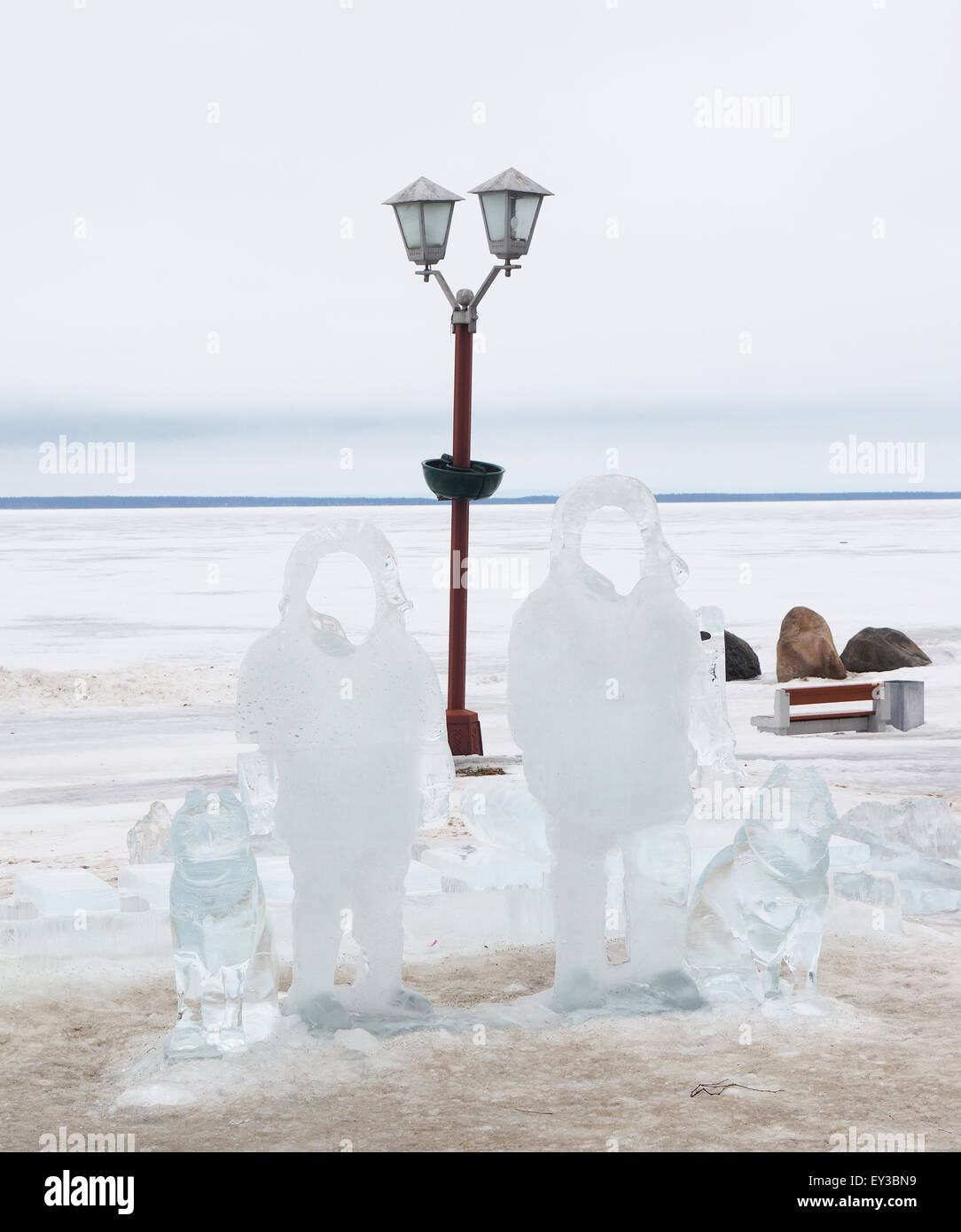 Eis-Statuen von Männern mit Hunden am See Stockfoto