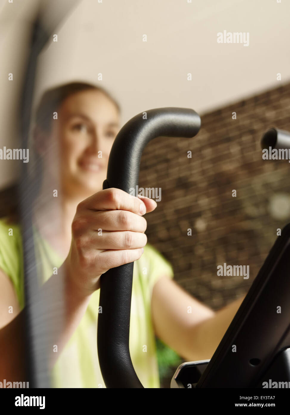 Junge Frau kümmert sich um seine Gesundheit und sie verwenden Ellipsentrainer, absichtliche Bewegung verwischen und engen Bereich der Tiefe Stockfoto