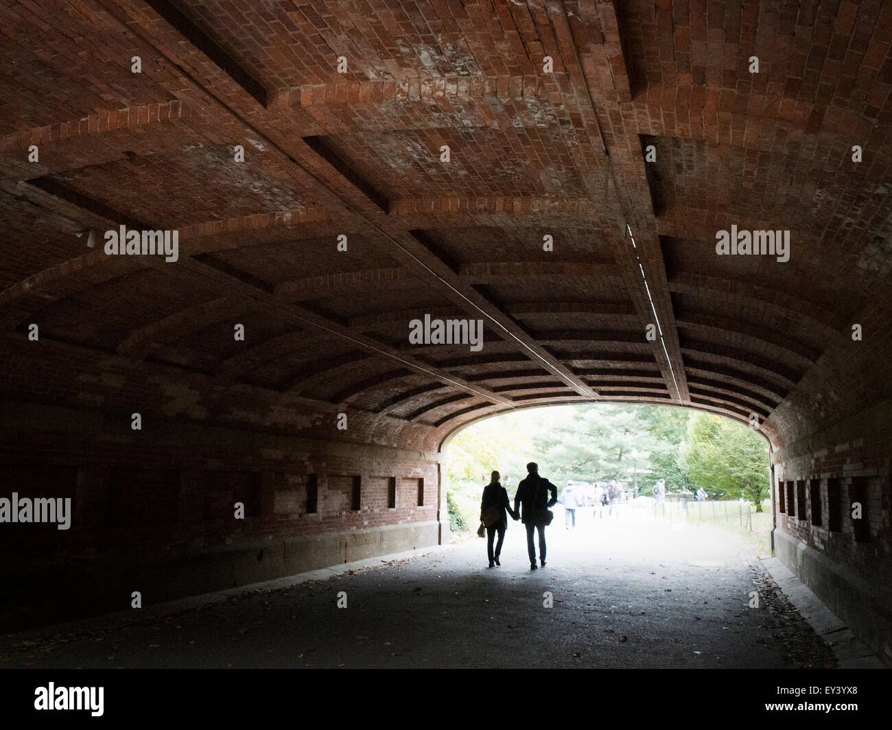Paar Hand in Hand zu Fuß durch einen Tunnel im Central Park in Manhattan. Stockfoto