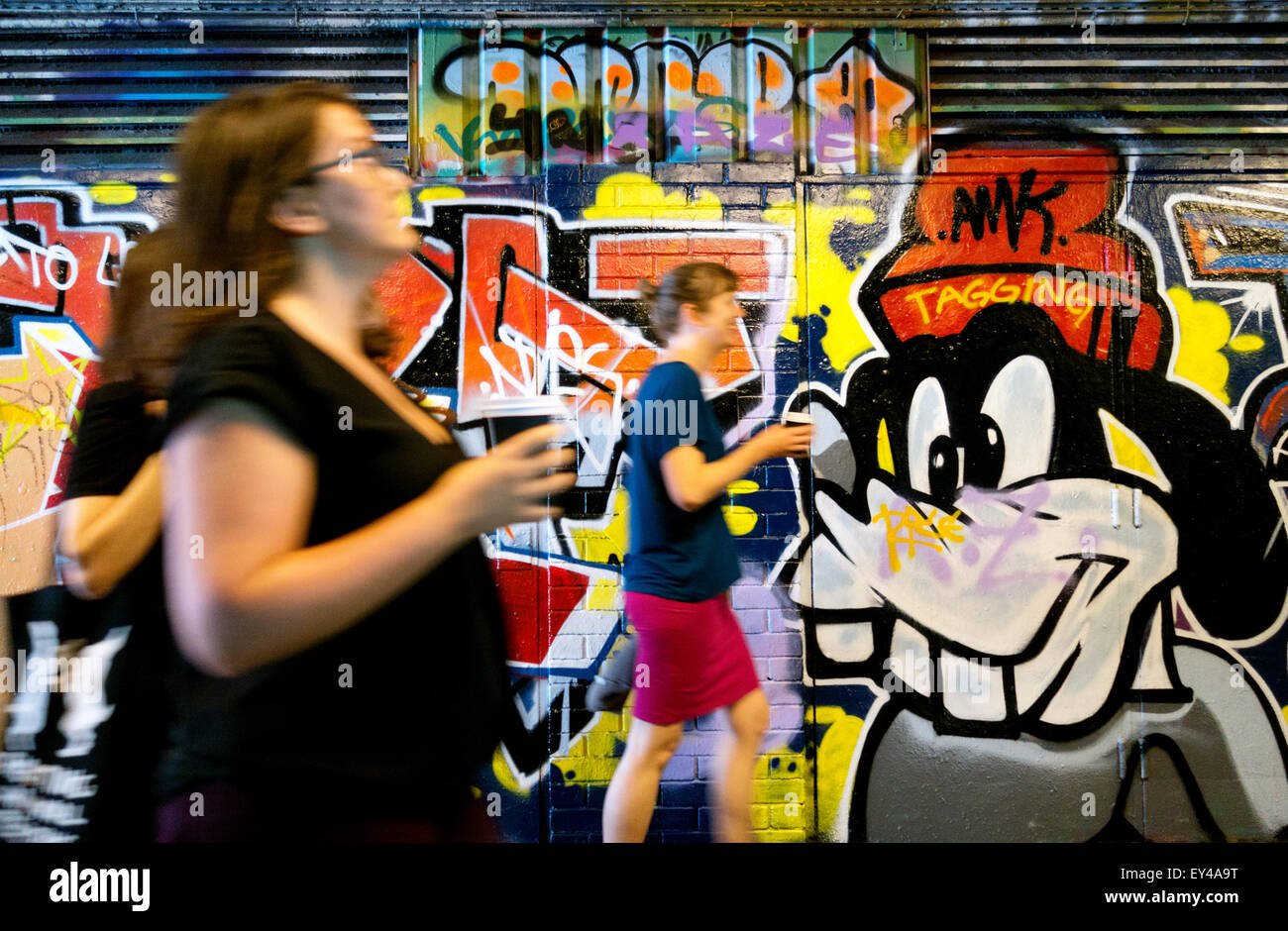 Menschen zu Fuß vorbei an der Graffiti an der Wand im Tunnel Leake Street, Waterloo, London England UK Stockfoto