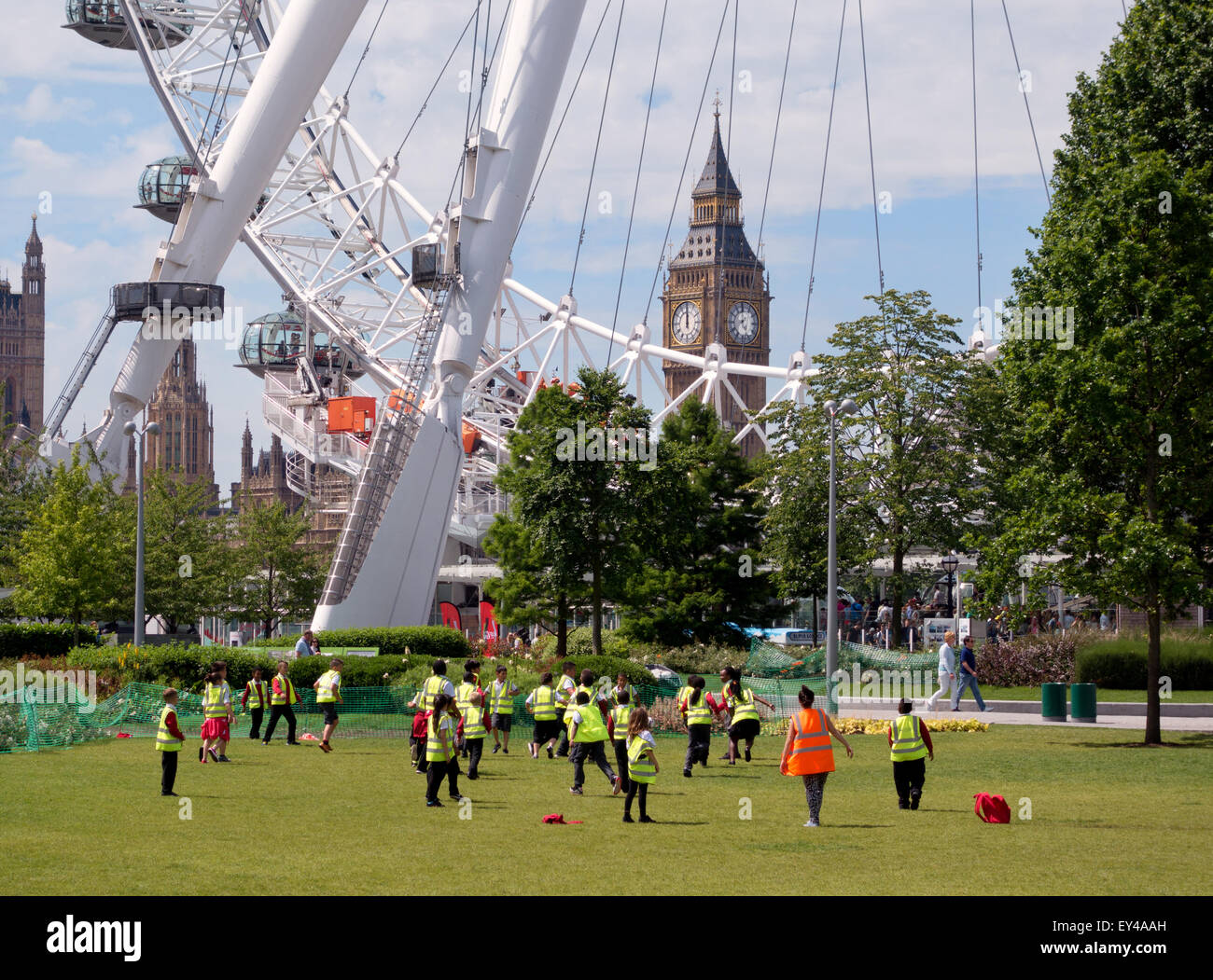 Kinder spielen Fußball im Freien in den Jubilee Gardens, South Bank, durch das London Eye, Big Ben im Hintergrund, London UK Stockfoto