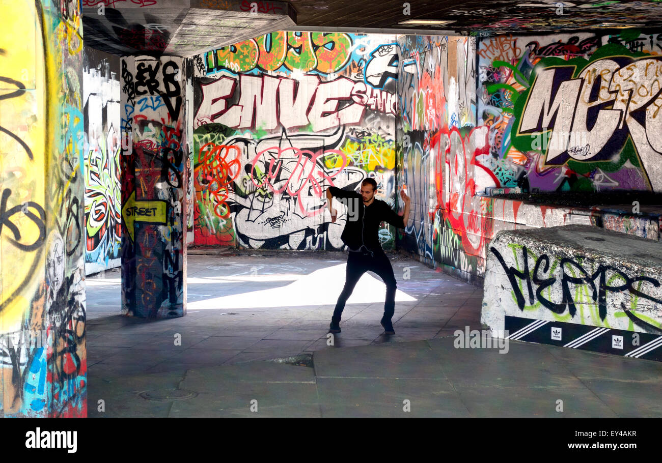 Eine Straße Entertainer üben seine Schritte, umgeben von Graffiti, Skate Park, South Bank, London UK Stockfoto