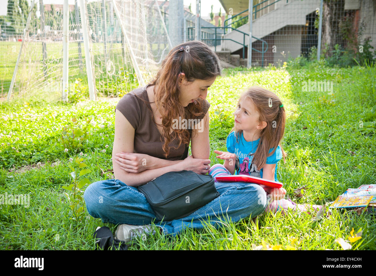 Frau und Kind spielt während der Sitzung in Grass Stockfoto