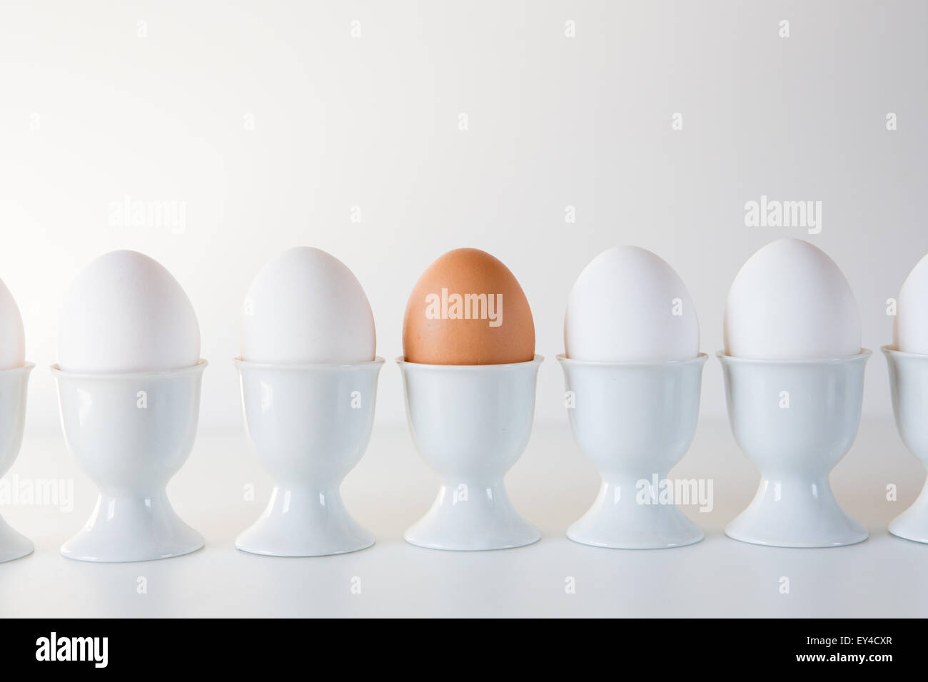 Braune Ei in Reihe von weißen Eiern, Nahaufnahme Stockfoto