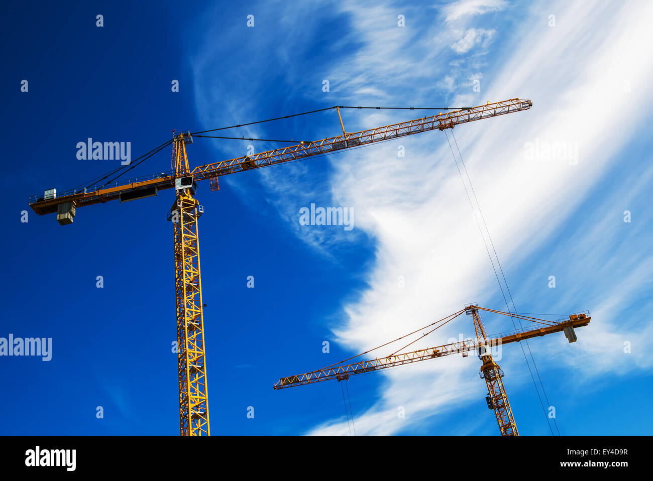 Industriekrane arbeitet auf Baustelle gegen blauen Himmel Stockfoto