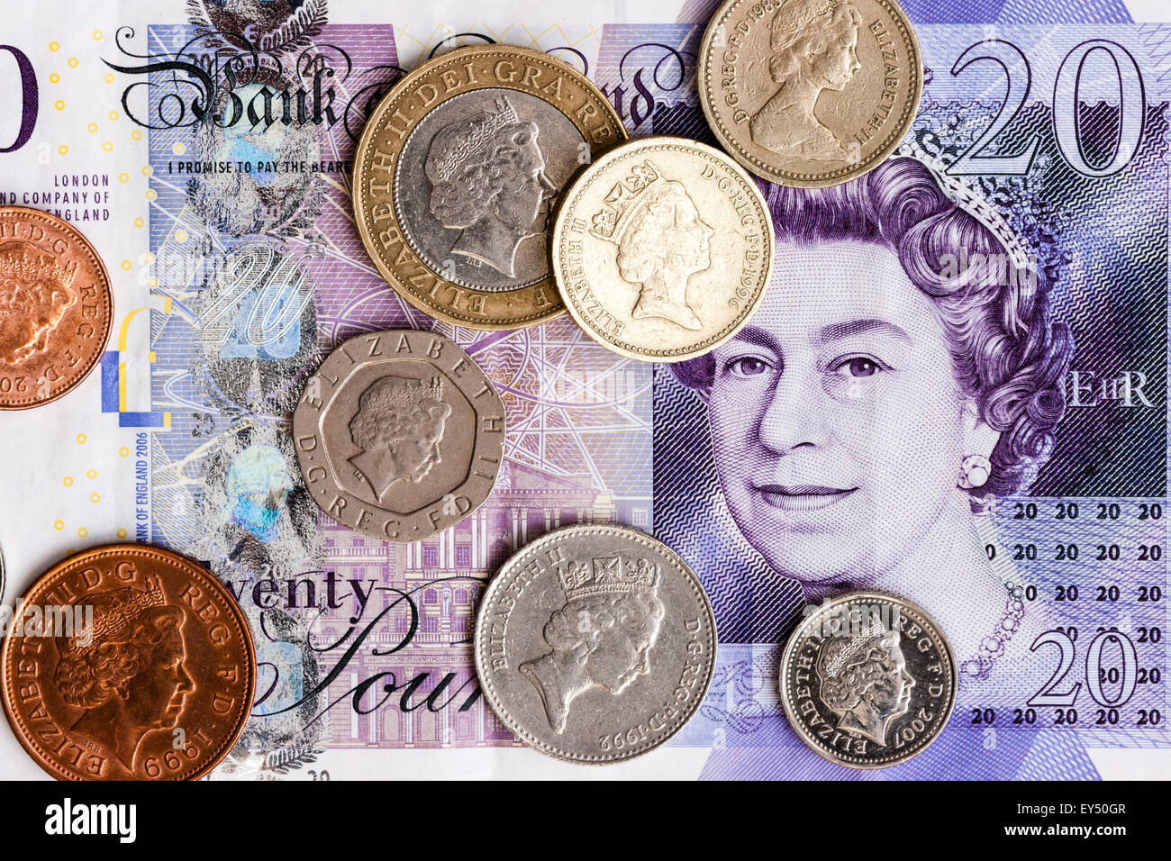Britische Währung. Diverse Münzen auf £ 20 Banknote verstreut. Mit der Pre-2017 £ 1 Münzen, Stockfoto