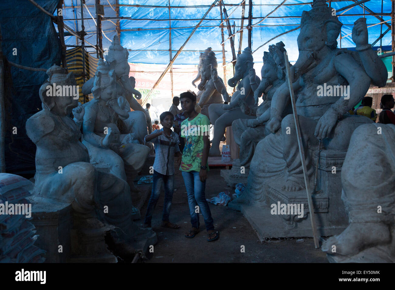 Indische Kinder stehen zwischen Unterplatte Idole der hindu-Gott Ganesha auf einen Wokshop in Mumbai, Indien. Stockfoto