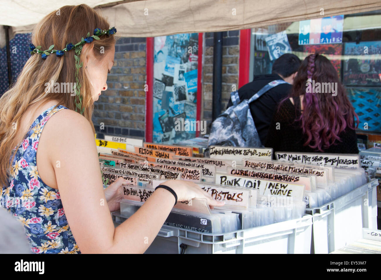 Mädchen auf der Suche aber Vinyl-Schallplatten in Camden Stables Market, London, UK Stockfoto