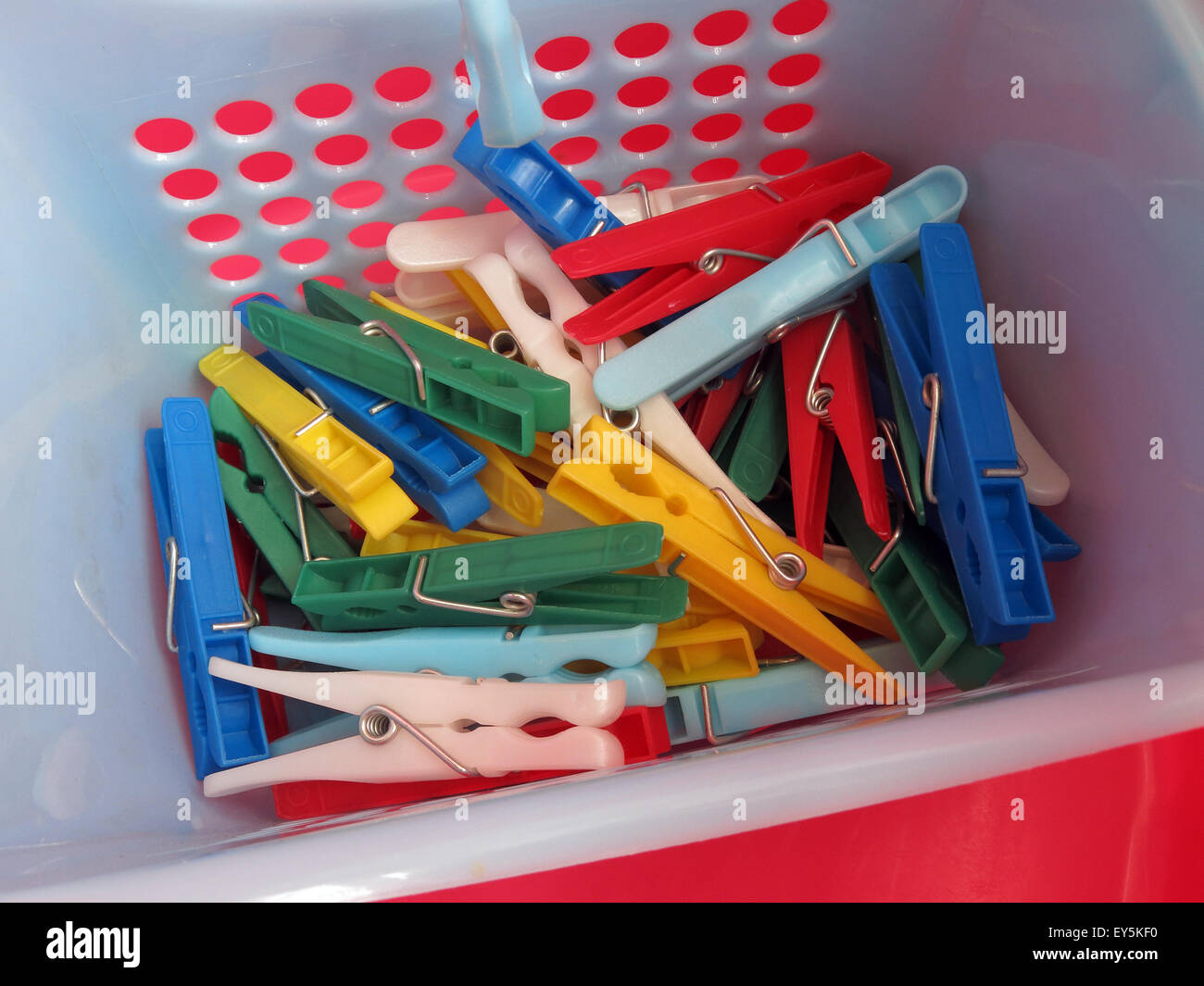 Hellen Waschtag Wäscheklammern für Wäscheleine, in rot, blau, gelb, grün, Korb Stockfoto