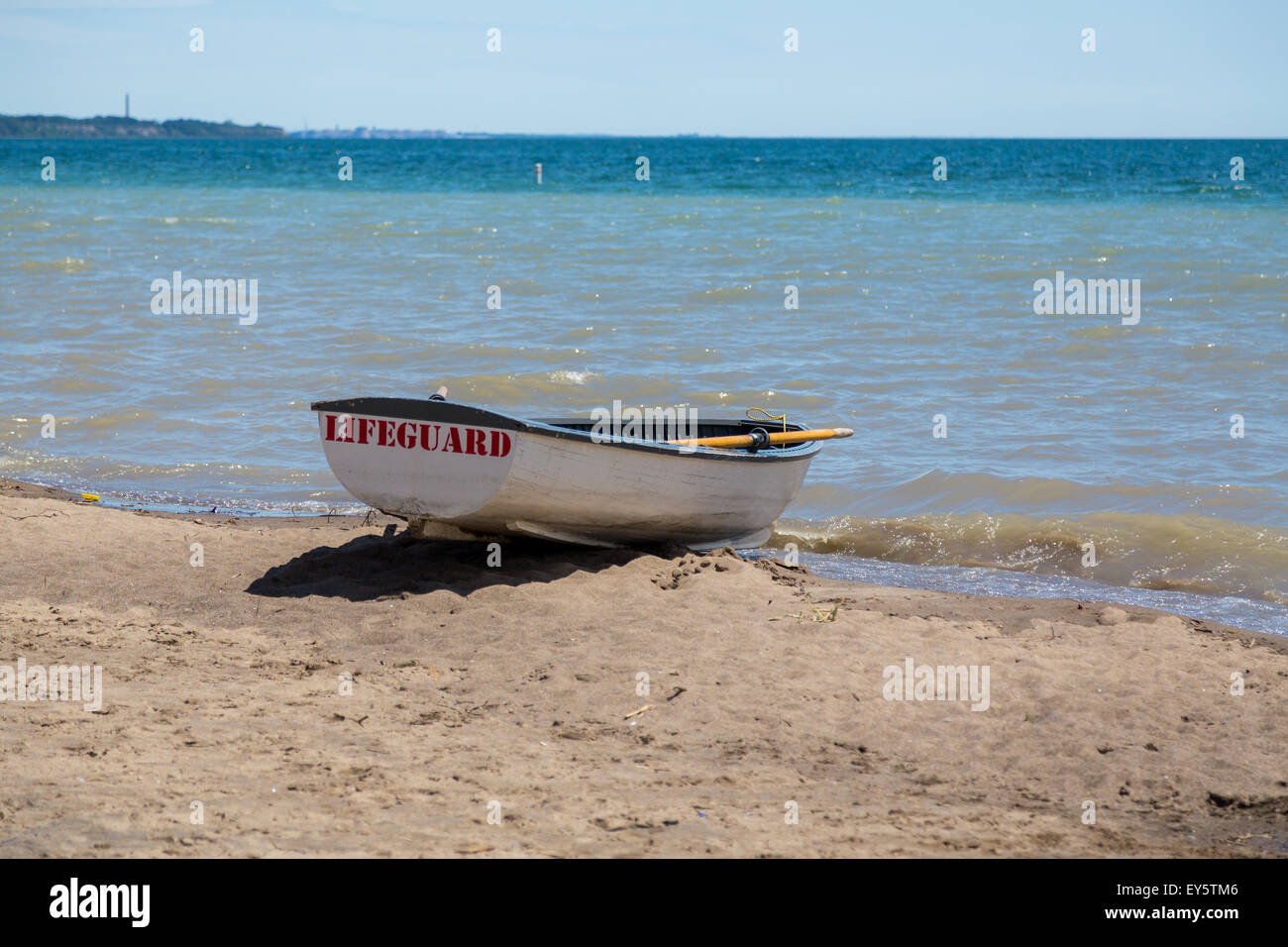 Ein Rettungsschwimmer-Boot am Wasser an einem Strand. Textfreiraum ist unterhalb und oberhalb des Bootes. Stockfoto
