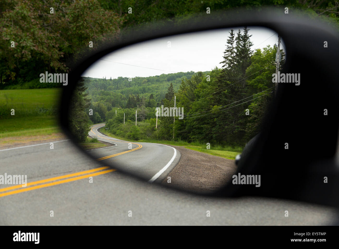 Die Aussicht auf windigen Straßen in Cape Breton aus einem Auto Außenspiegel Stockfoto