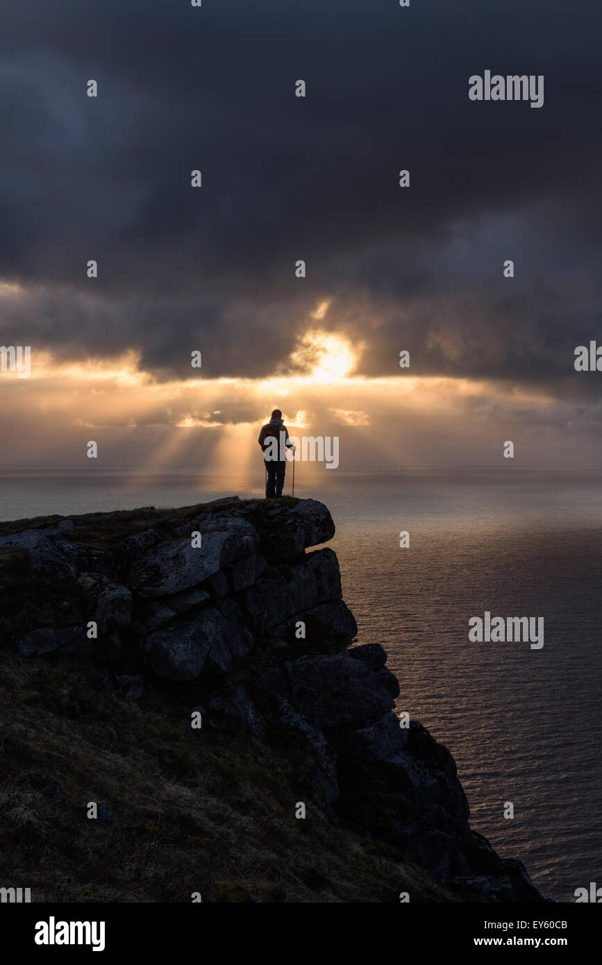 Weibliche Wanderer Uhren Mitternachtssonne über Meer von Nonstind Berggipfel, Leknes, Lofoten Inseln, Norwegen Stockfoto