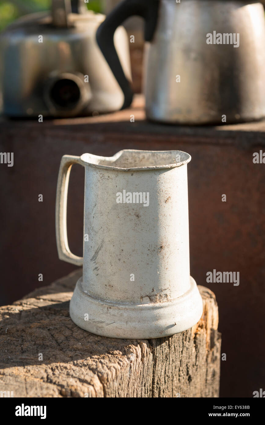 Alte Zinn Krug in einer Außenküche sitzen auf Alter Holz Stockfoto