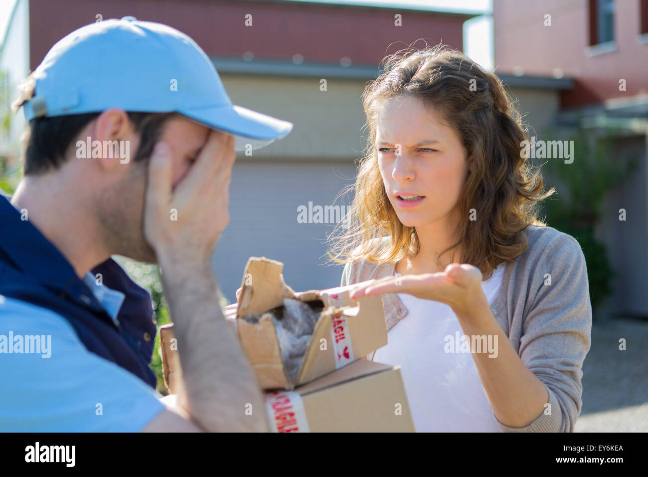 Blick auf eine junge attraktive Frau wütend gegen Lieferung Mann Stockfoto