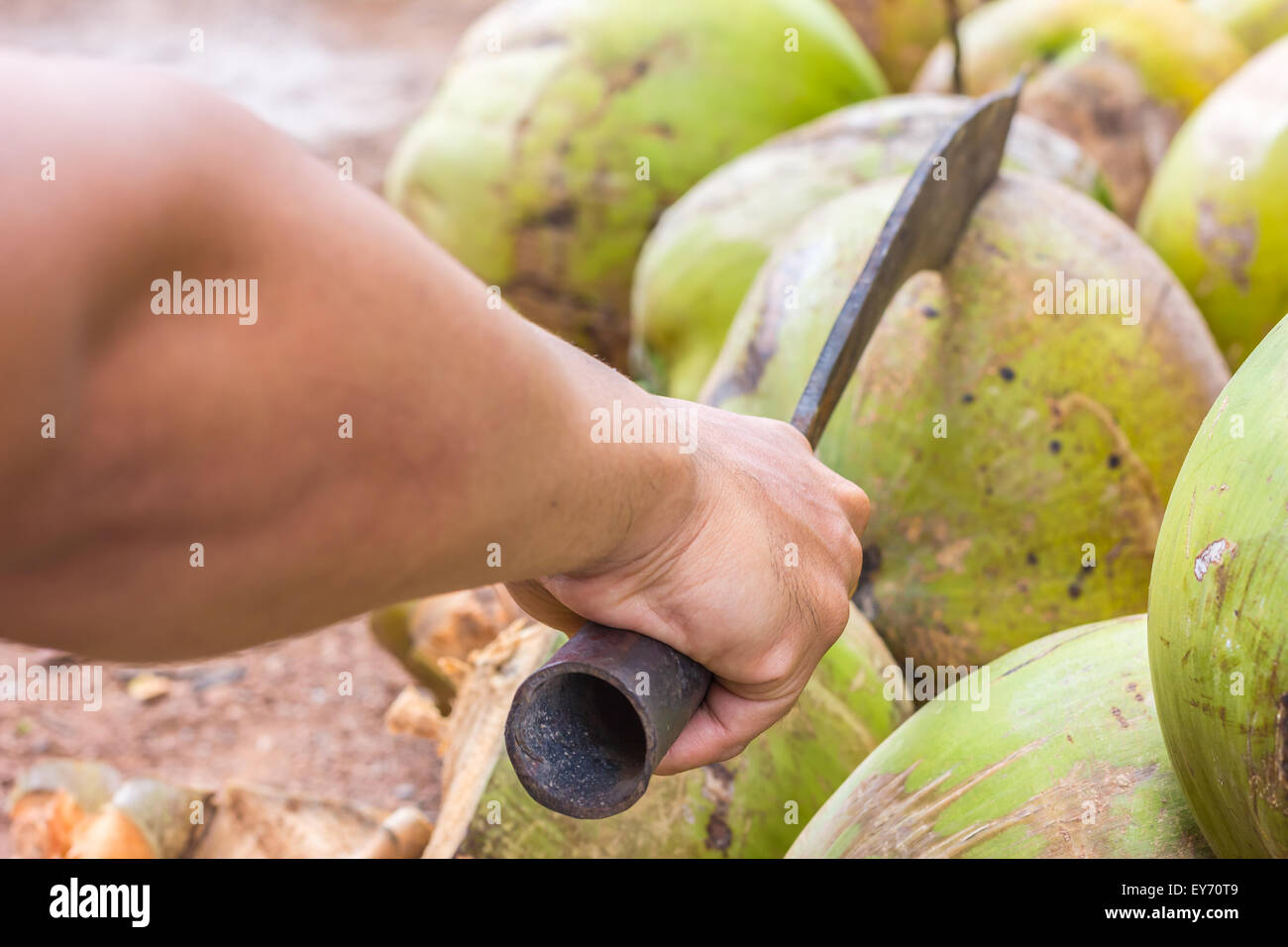 Zeigen Sie Mann, nur Hand, Kokos von großen Messer hacken Stockfoto