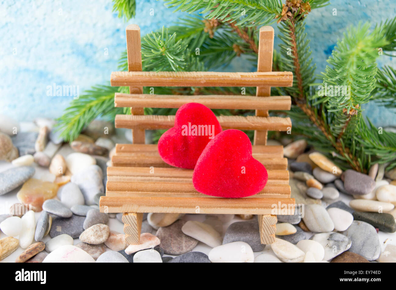 Szene gesetzt mit zwei Herzen auf einer Miniatur-Holzbank Stockfoto