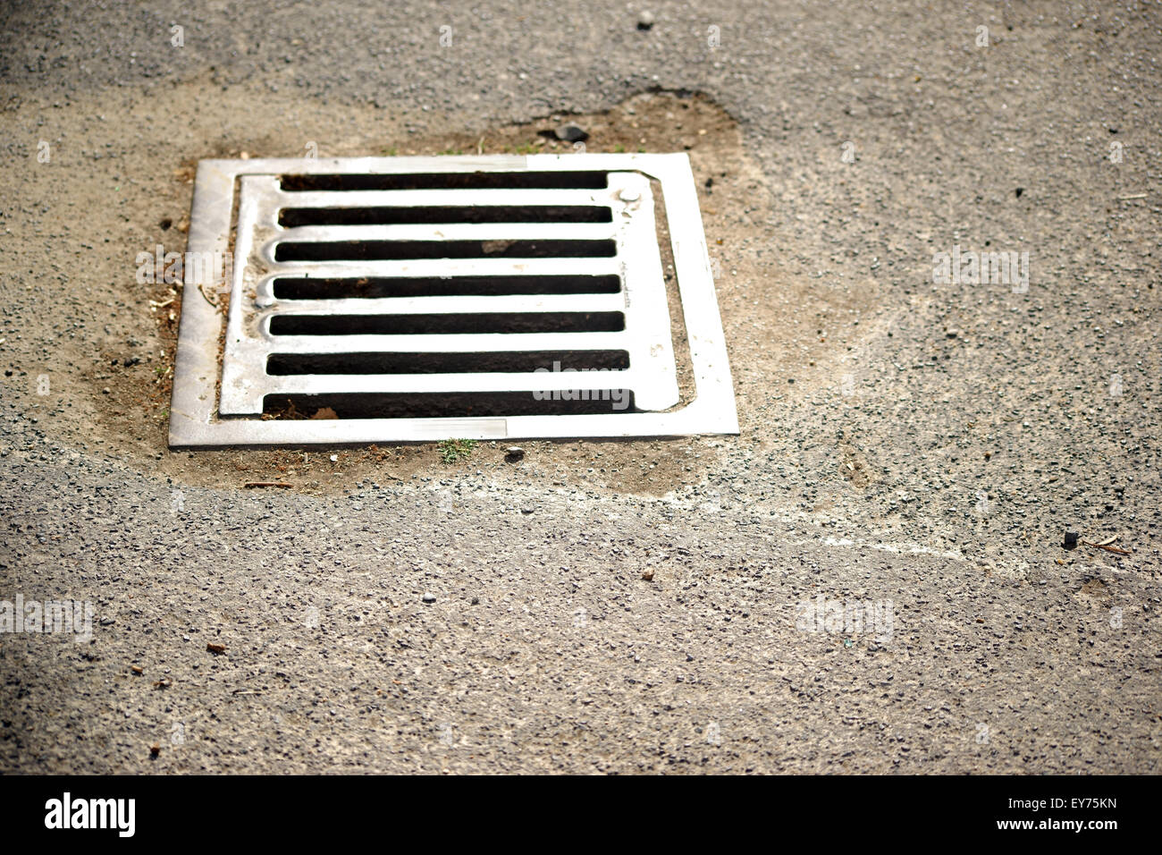 Asphaltstraße mit Abfluss Stockfoto