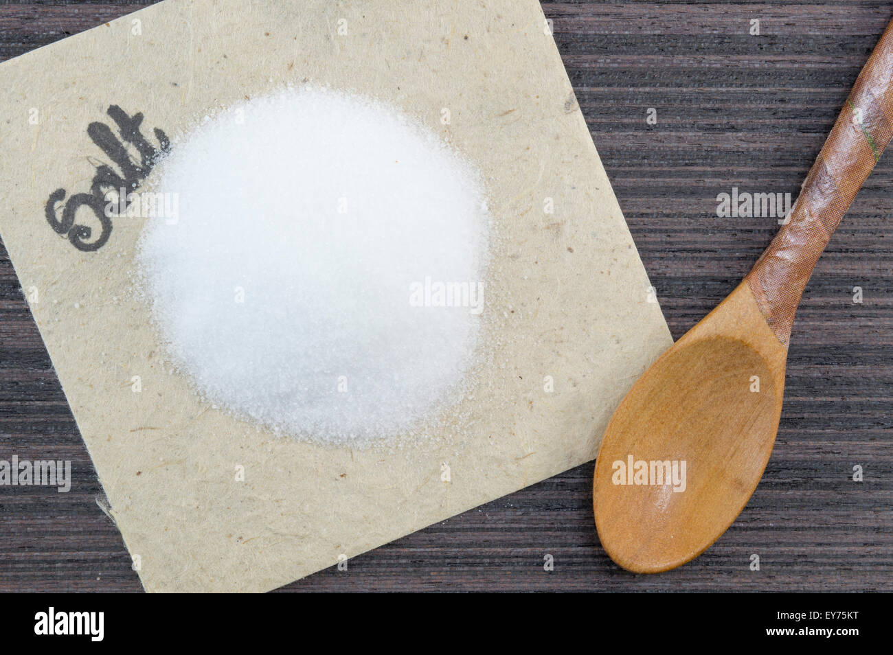 Haufen von Salz und einem hölzernen Löffel auf dem Tisch Stockfoto