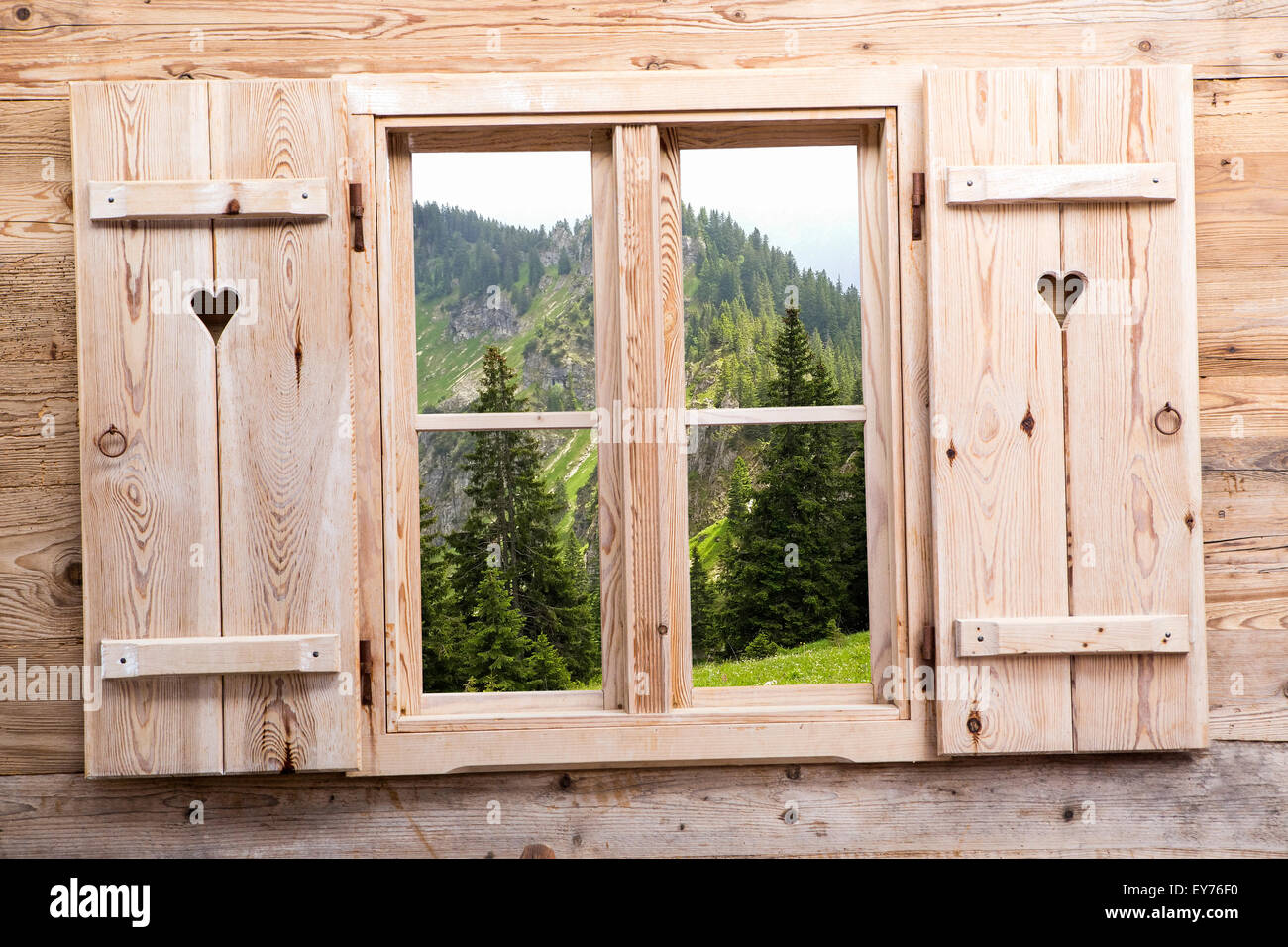 Holzfenster mit sommerlichen Berg als Reflexionen Stockfoto