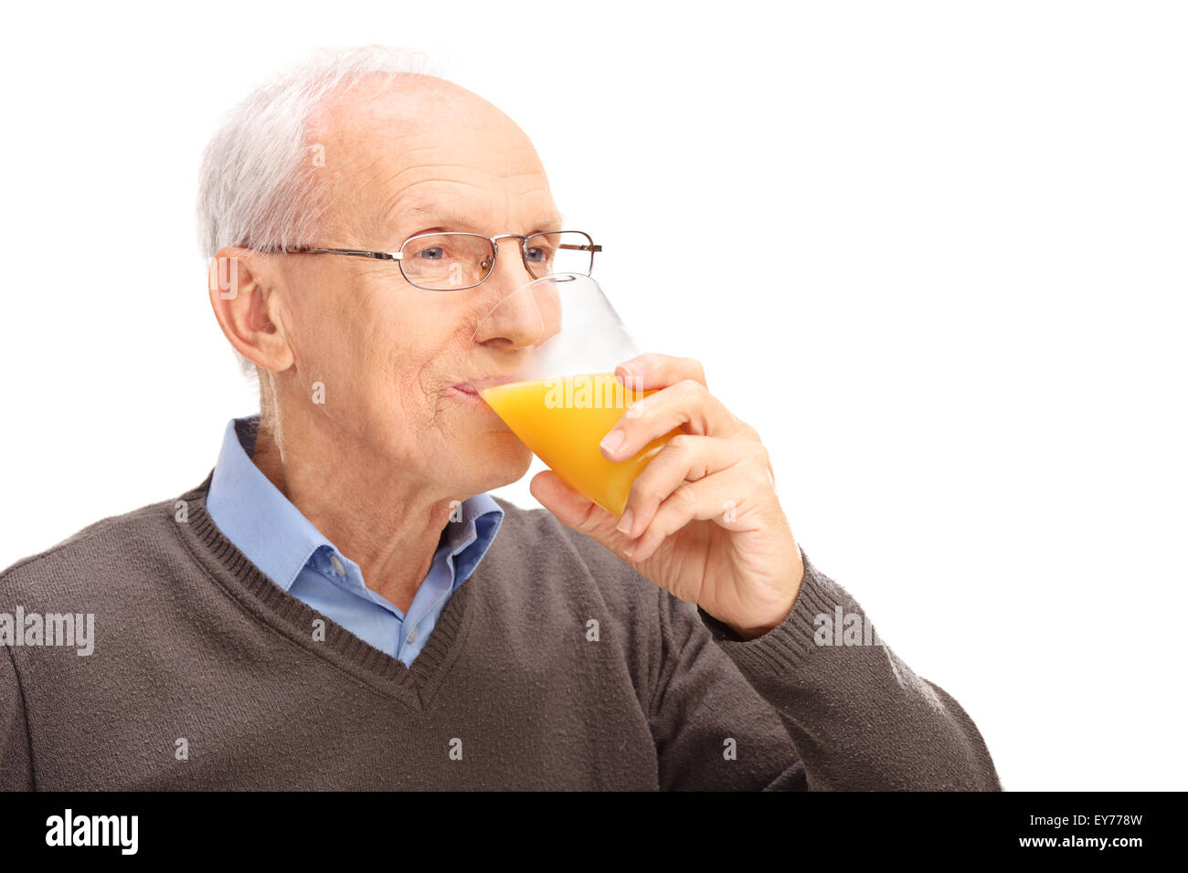 Studioaufnahme eines Senioren trinken Orangensaft isoliert auf weißem Hintergrund Stockfoto