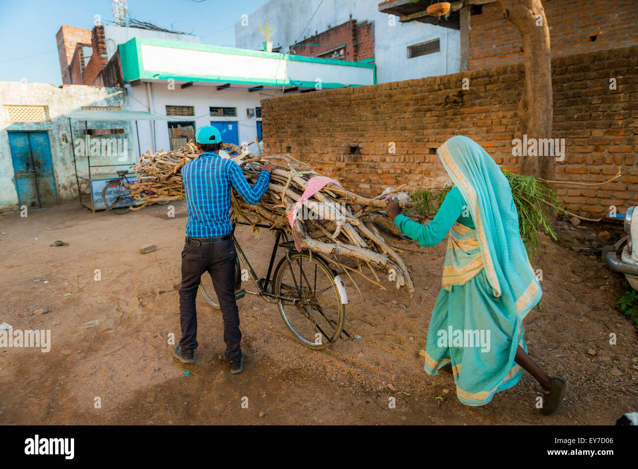 Mann und Frau mit Brennholz auf einem Fahrrad in Khajuraho, Madhya Pradesh, Indien Stockfoto