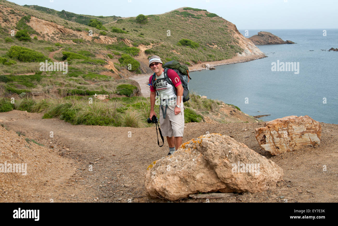 Ein Wanderer geht entlang einer felsigen nördlichen Küste der Braut Cami de Cavalls Trail auf der Insel Menorca Spanien Stockfoto