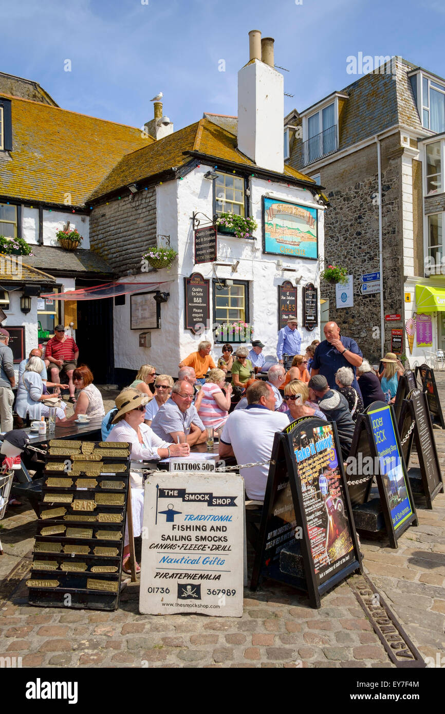 St. Ives, Cornwall, England, UK im Sommer - Touristen sitzen außerhalb der alten Sloop Inn-Kneipe am Hafen Stockfoto