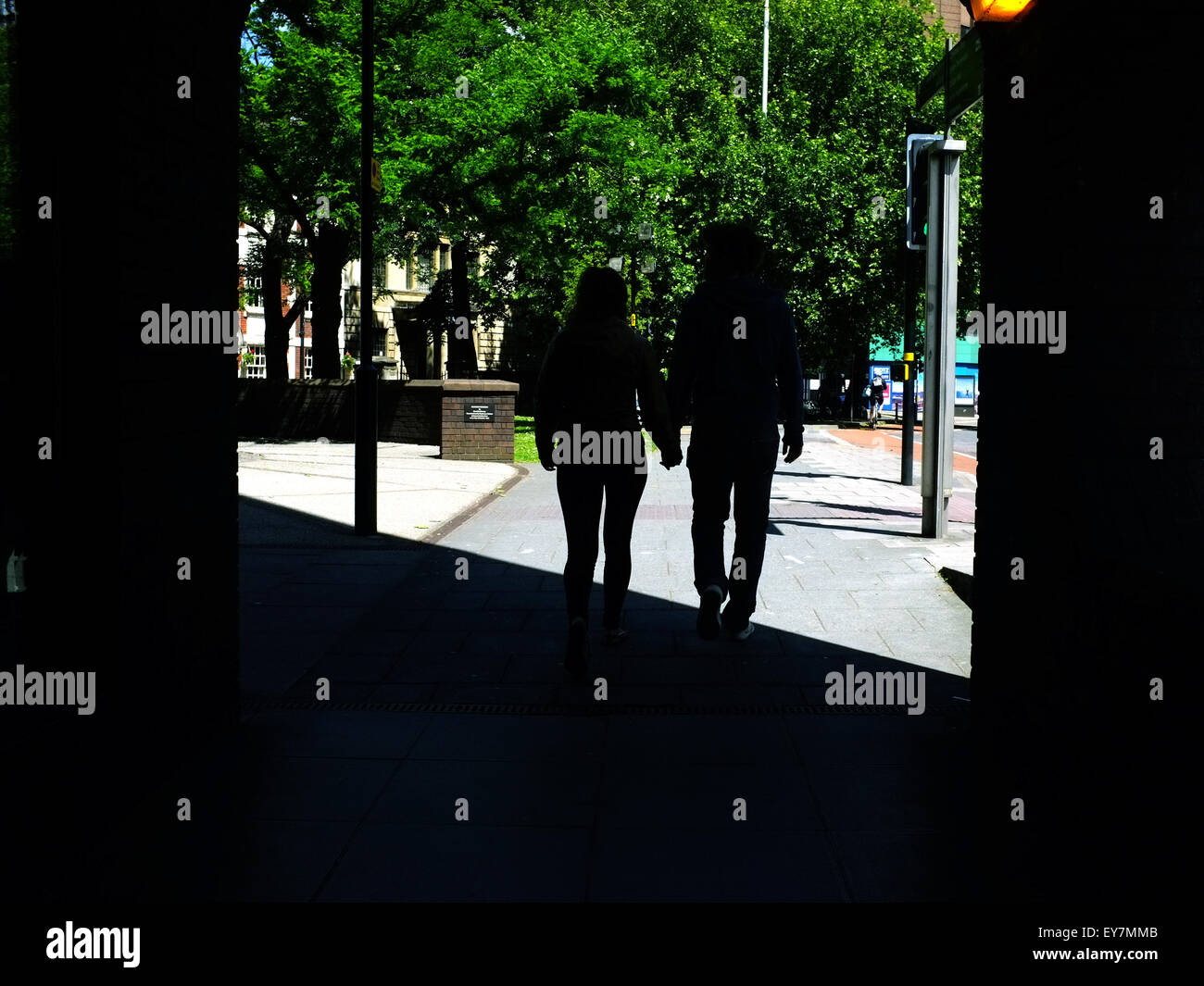 Die Silhouetten von Menschen zu Fuß aus einem Gebäude und in die Sonne. Stockfoto