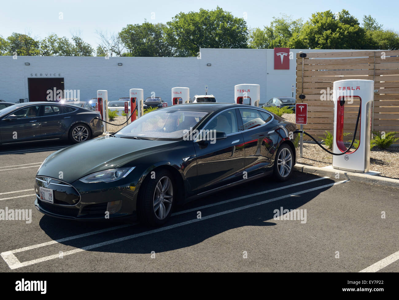 Ladestation mit einem Tesla Limousine Elektroauto eingesteckt. Tesla-Händler, Paramus, NJ Stockfoto