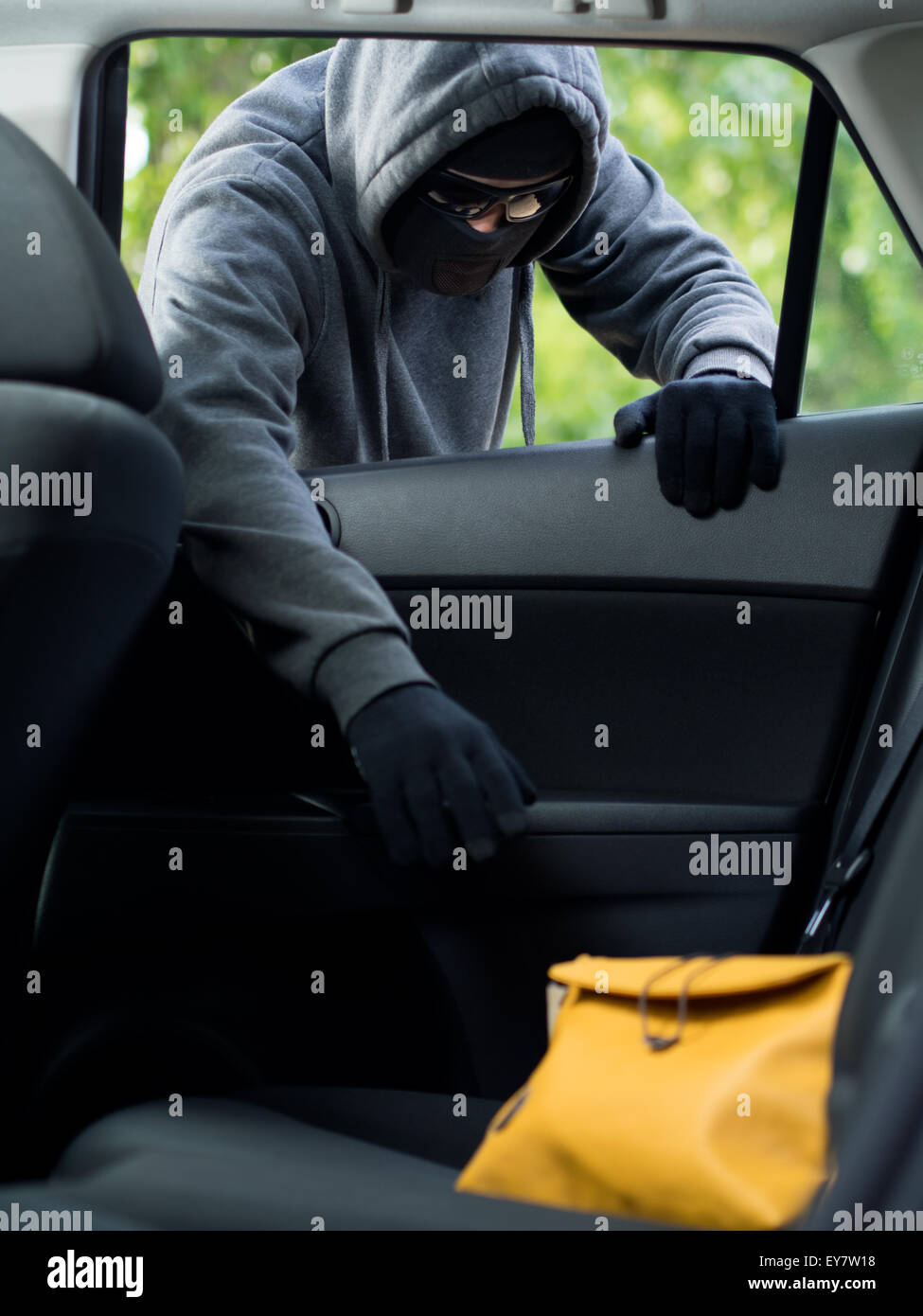 Verkehrskonzept Verbrechen. Dieb stiehlt Tasche aus dem Auto Stockfoto