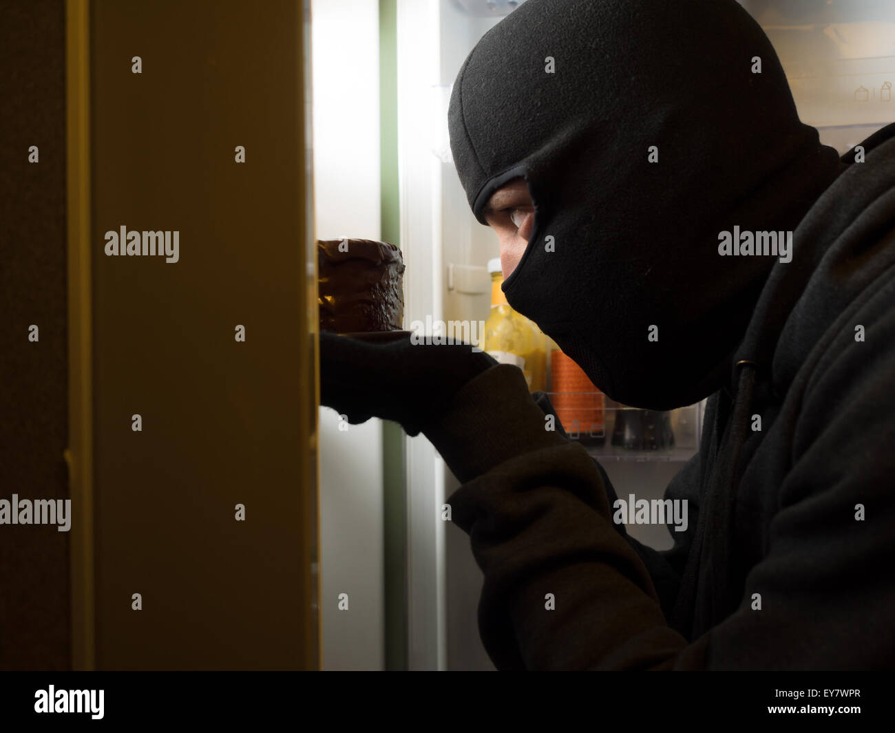 Dieb. Mann mit schwarzer Maske mit einem Kuchen. Stockfoto