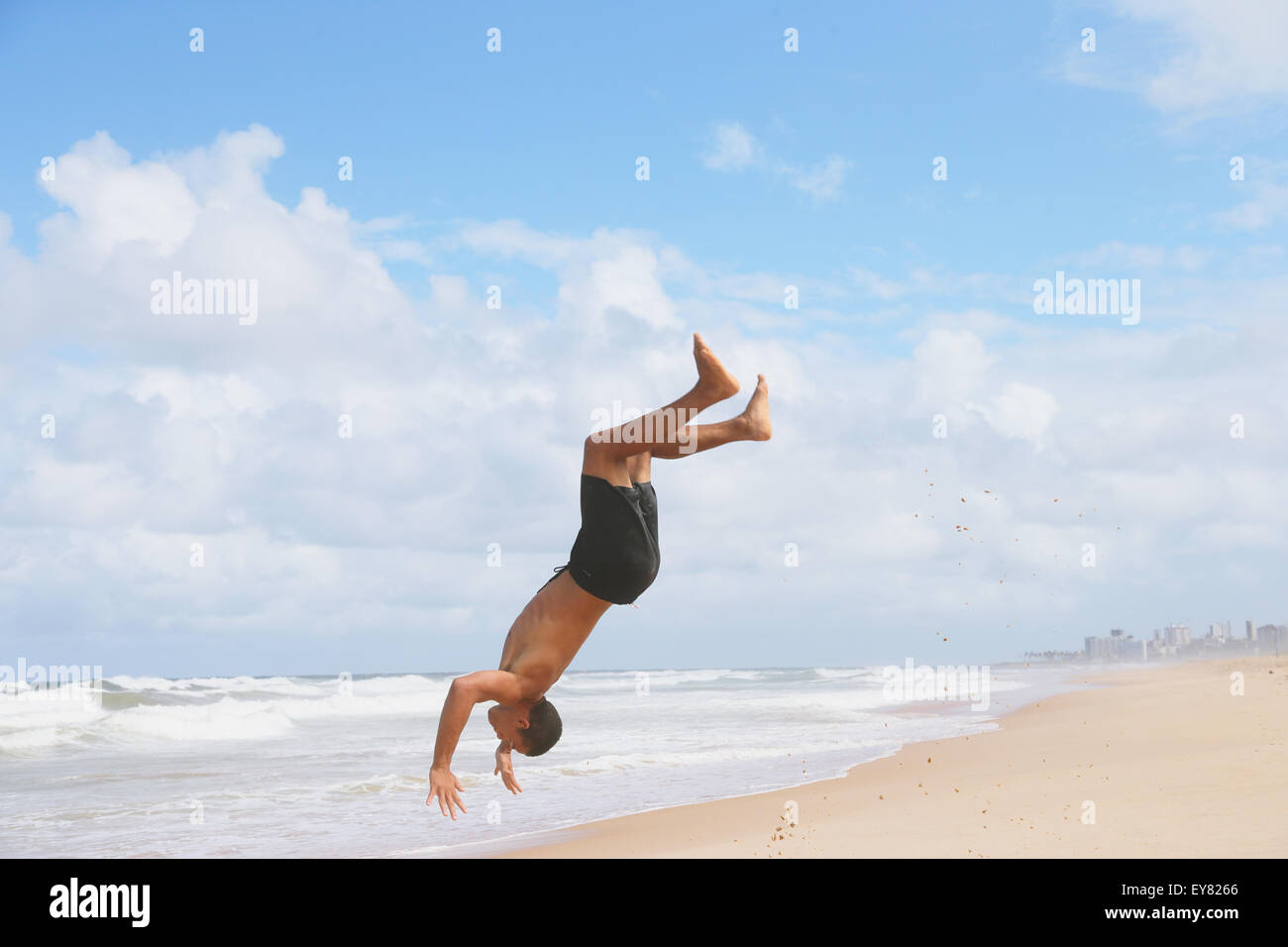 Mann springt auf den Strand, Salvador, Brasilien Stockfoto