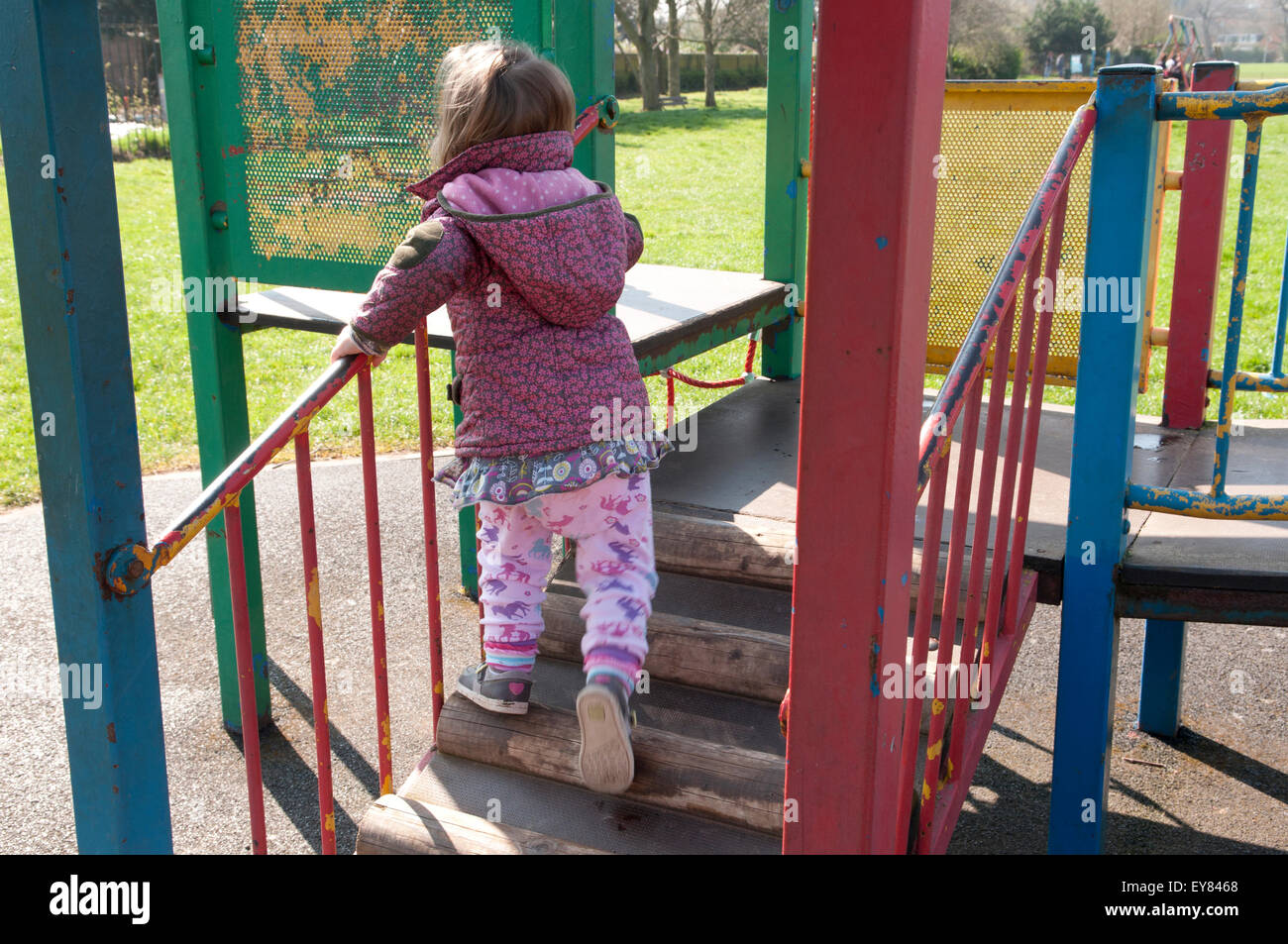 Kleinkind spielt auf einem Klettergerüst im park Stockfoto