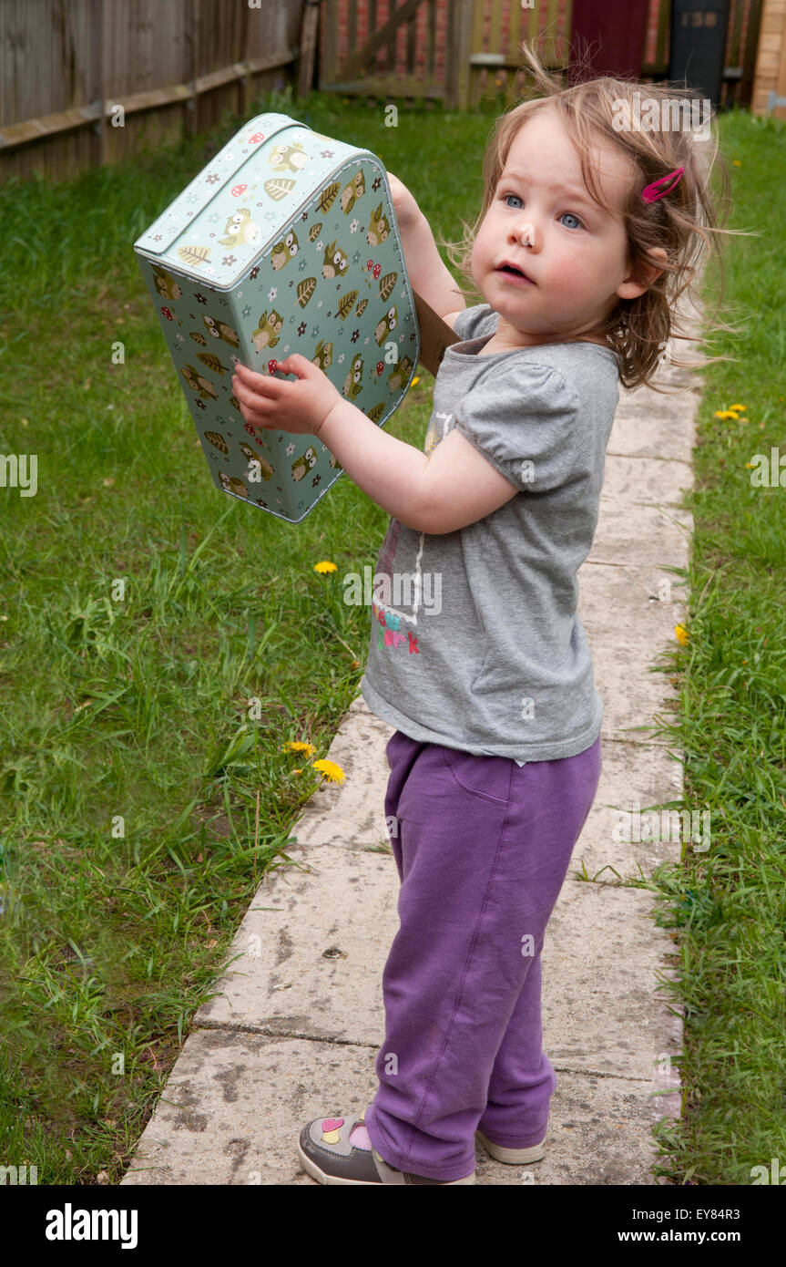 Kleines Mädchen zufrieden mit ihren Mini-Koffer Stockfoto