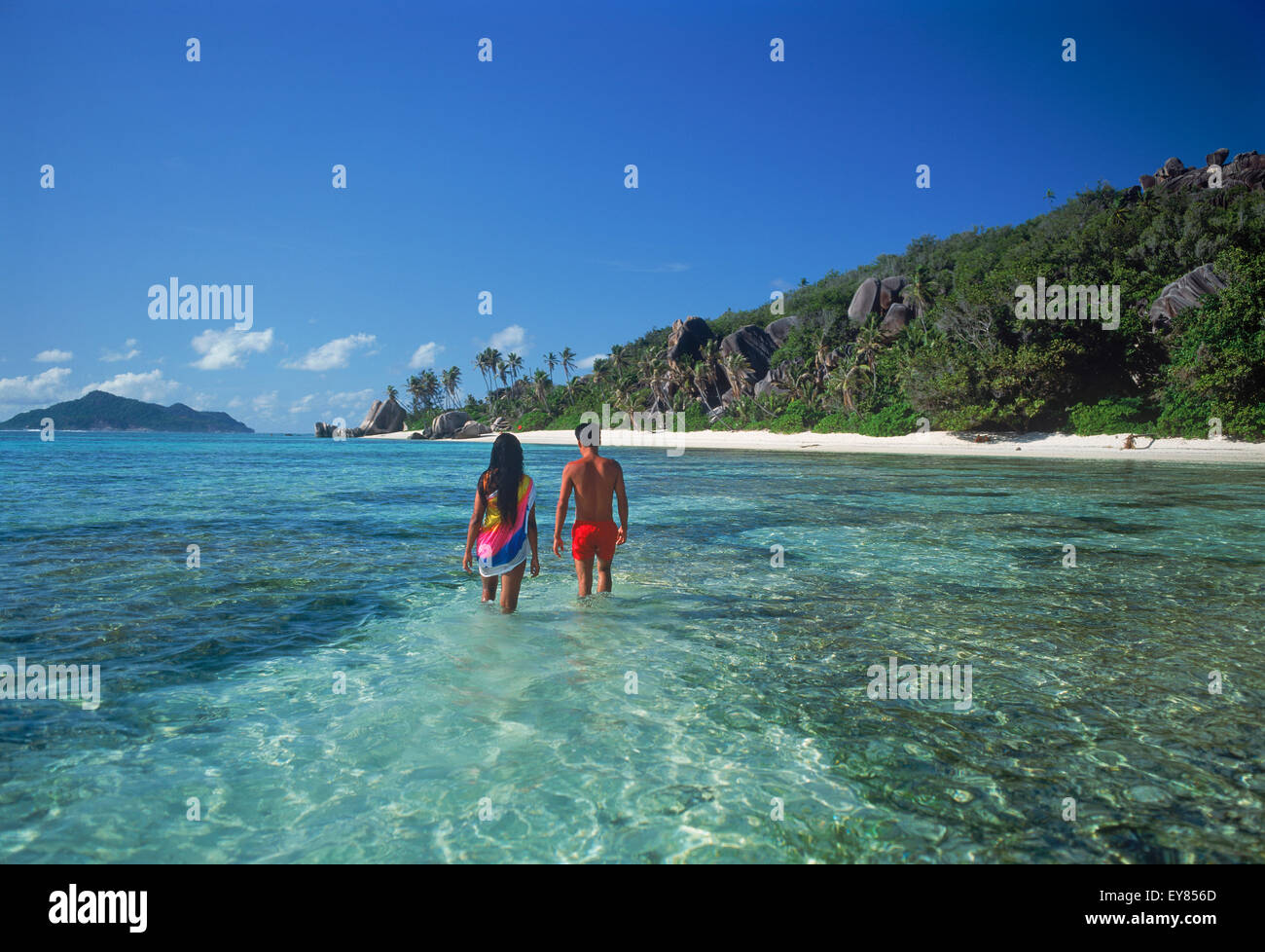 Lokales Paar, das durch die Wasserlagune bei Anse Source d Argent auf La Digue auf den Seychellen Stockfoto