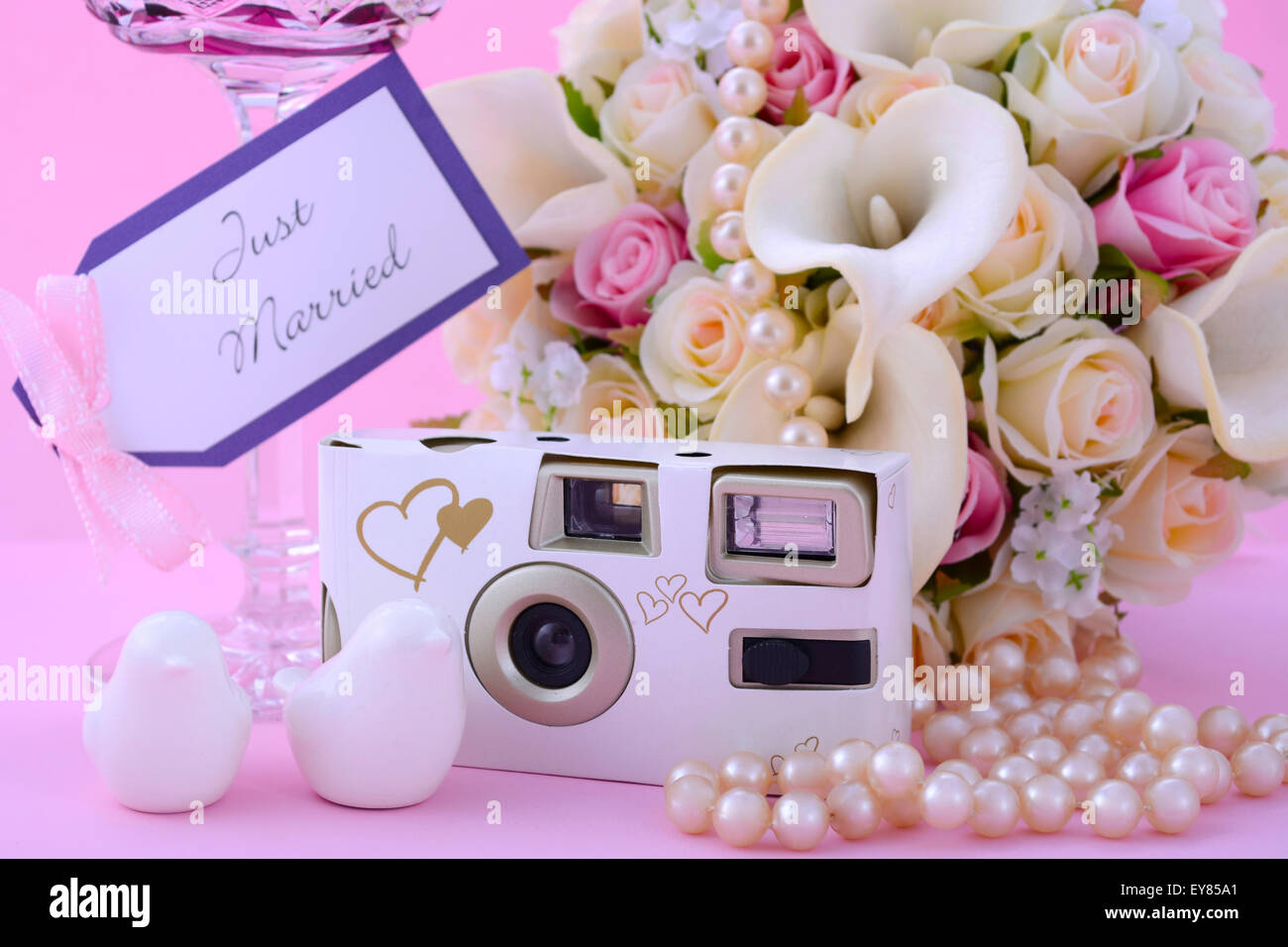 Thema Hochzeit Tisch Gedeck mit Einweg-Kamera, Bouquet und Vintage pink Crystal Weinglas. Stockfoto