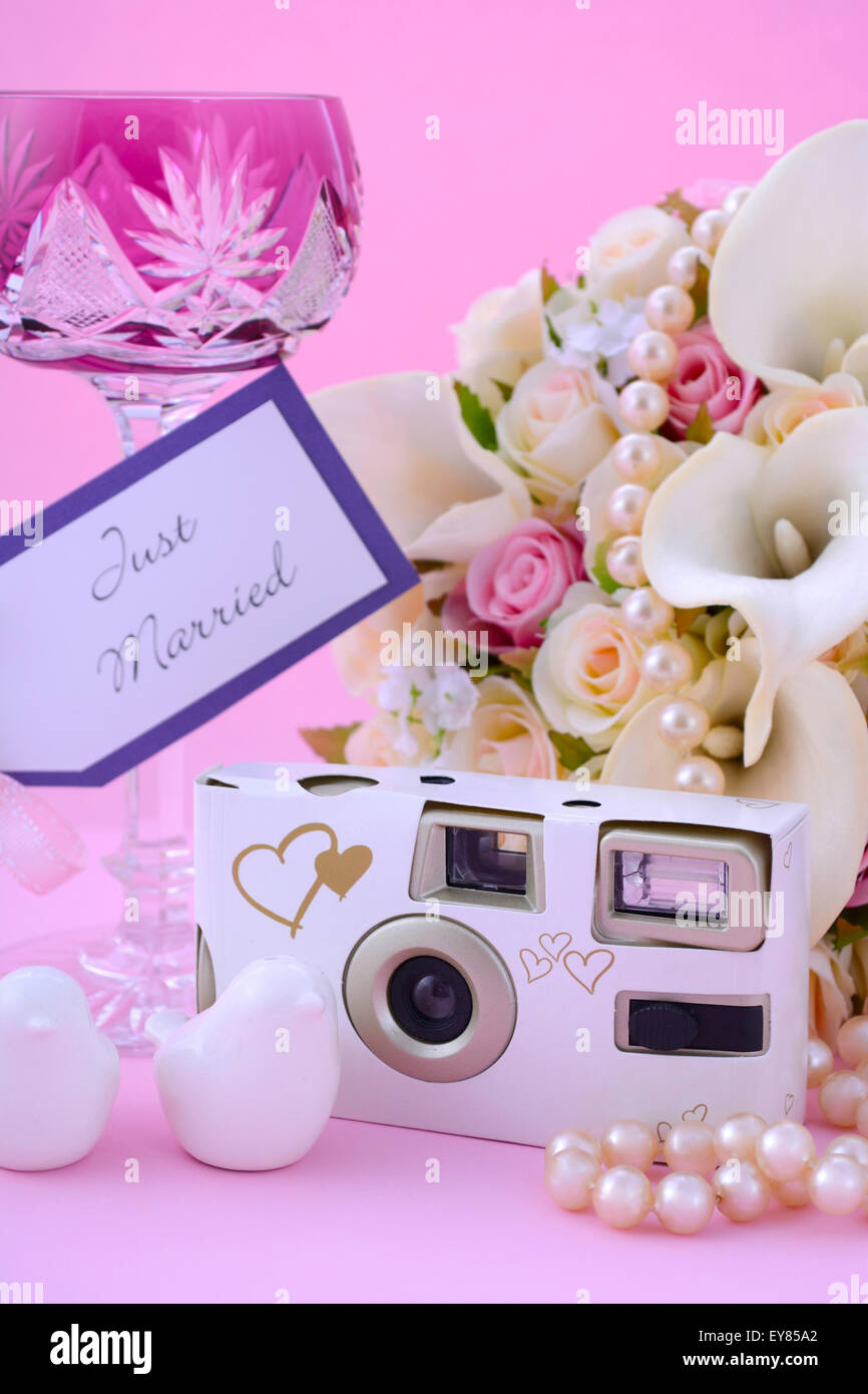 Thema Hochzeit Tisch Gedeck mit Einweg-Kamera, Bouquet und Vintage pink Crystal Weinglas. Stockfoto