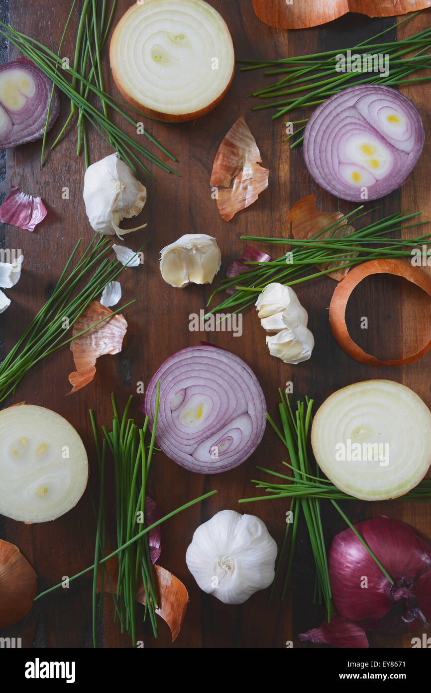 Zwiebeln, Schnittlauch und Knoblauch verstreut auf Holztisch für die Zubereitung von Speisen und Koch-Konzept, mit angewandter Retro-Vintage-Stil-fil Stockfoto