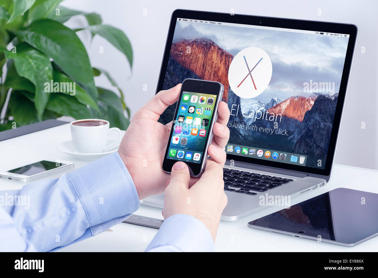 Apple MacBook Pro Retina mit angekündigt auf WWDC 2015 OS X El Capitan auf dem Bildschirm und Apple iPhone 5 s mit iOS 9 auf dem display Stockfoto