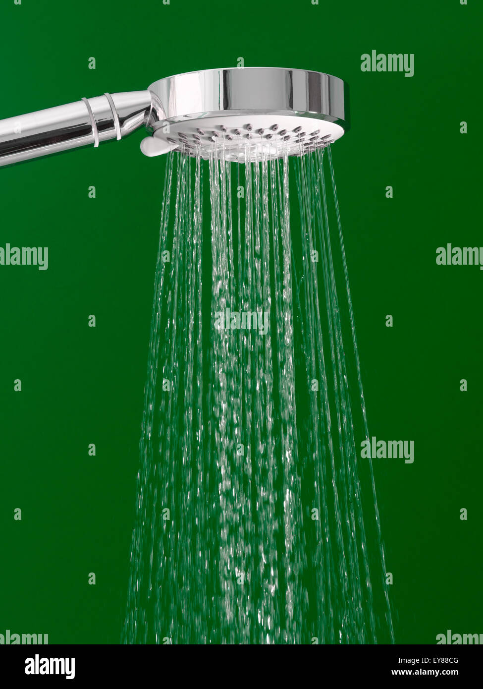 Duschkopf mit fließendem Wasser auf grünem Hintergrund Stockfoto
