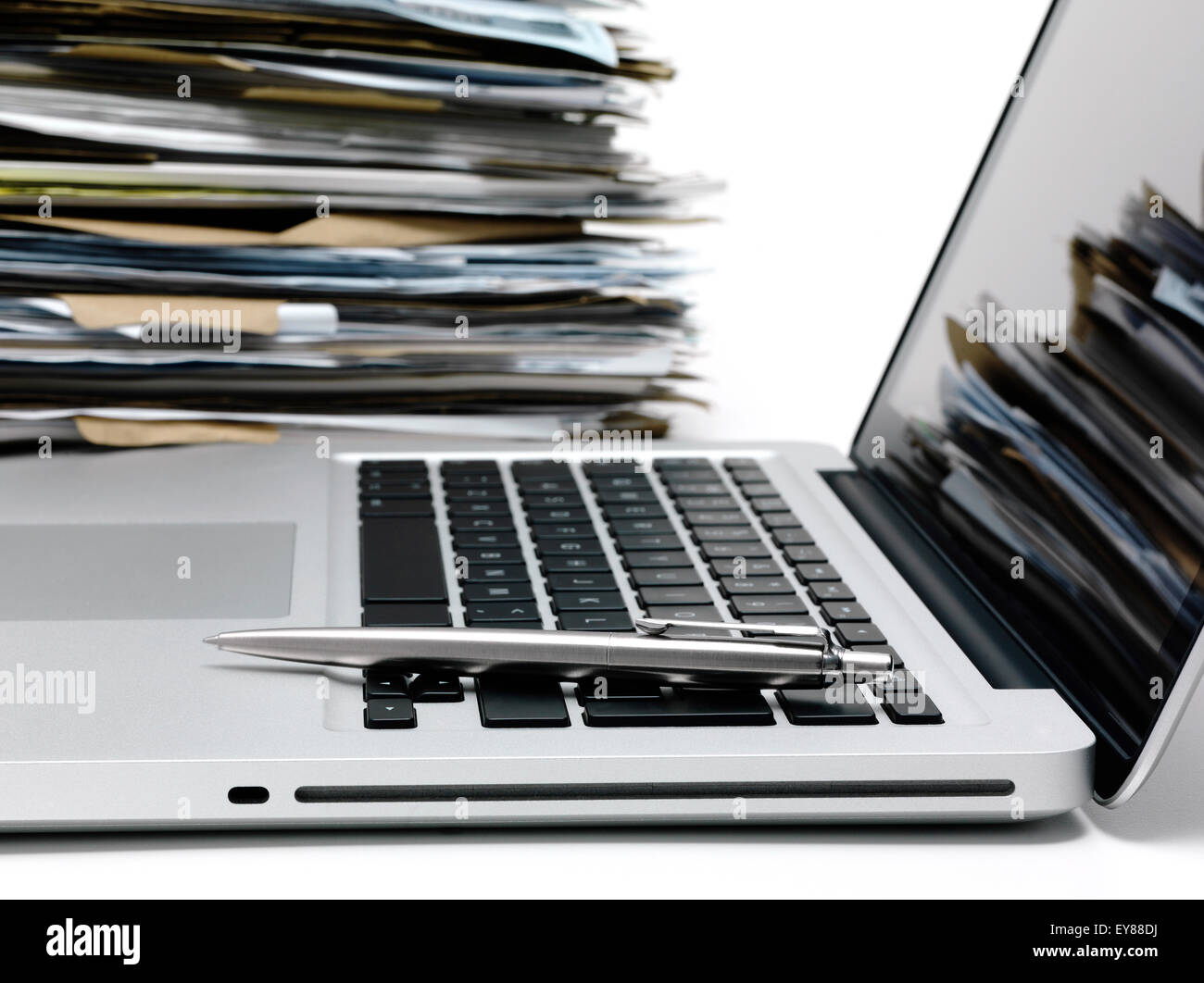Laptop mit einem Haufen von Dateien im Hintergrund Stockfoto